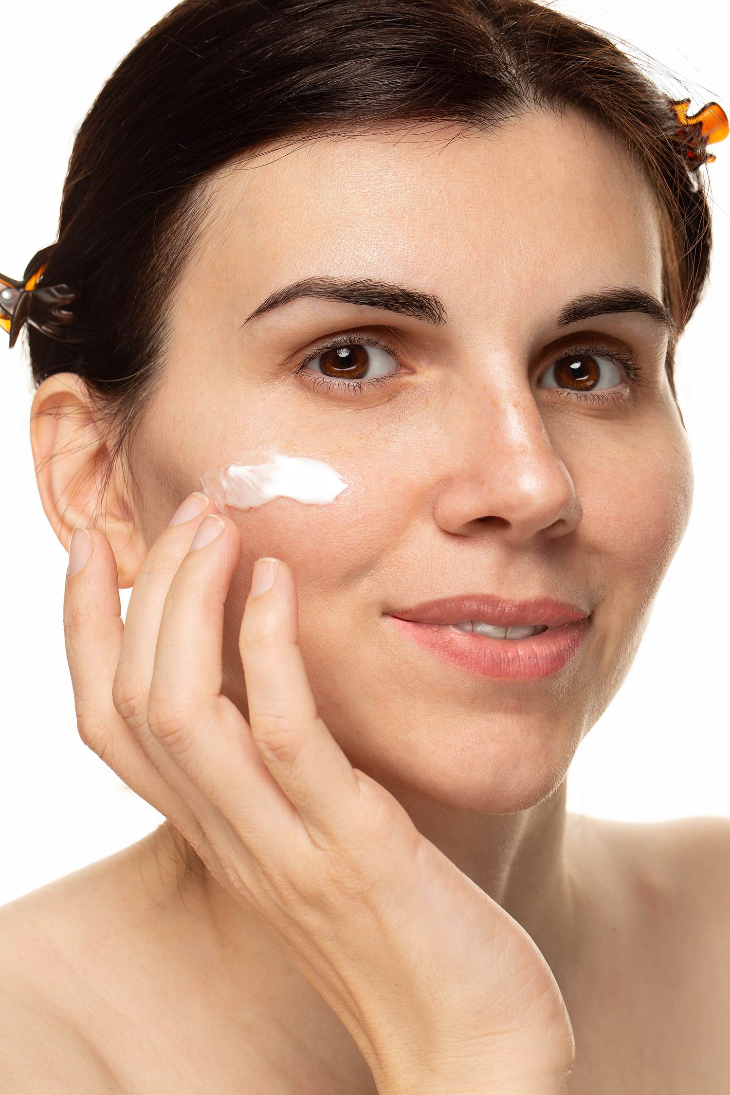 Natural beauty portrait showing skincare routine with facial cream application.