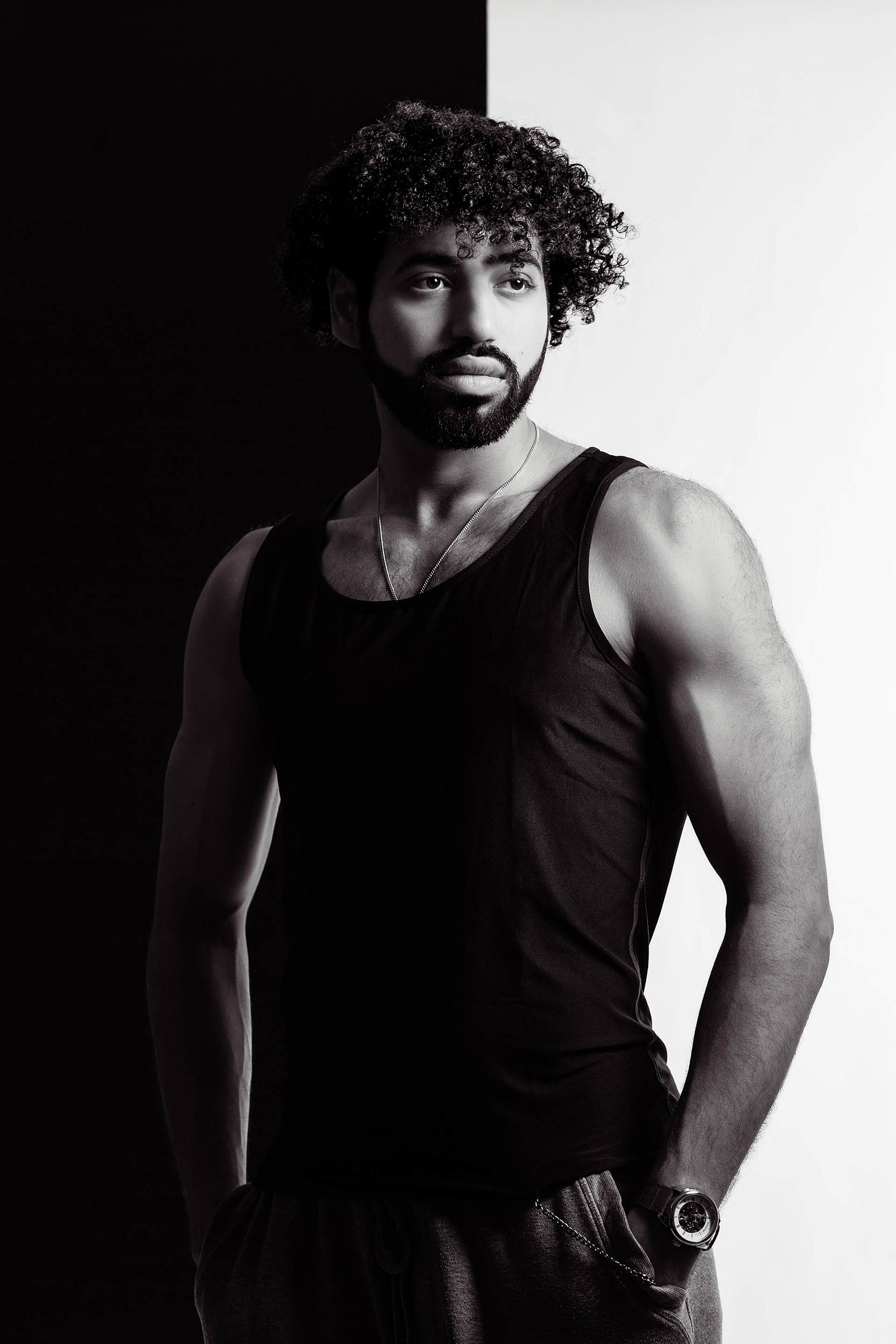 Black and white portrait series showing dramatic lighting on a muscular figure in a dark tank top.