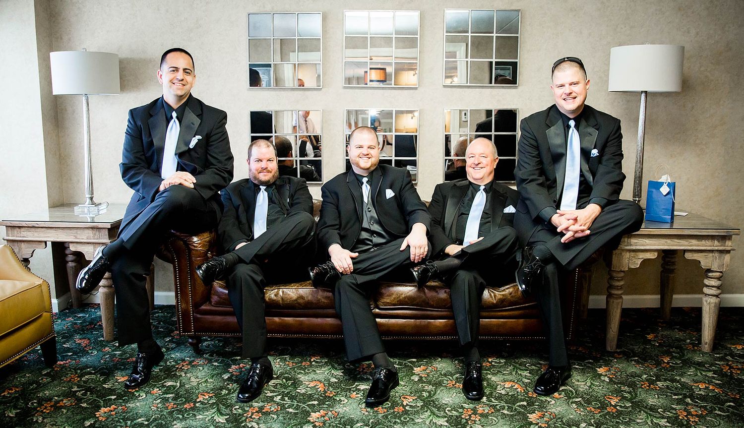 Formal group portrait on an elegant sofa in a well-appointed room.