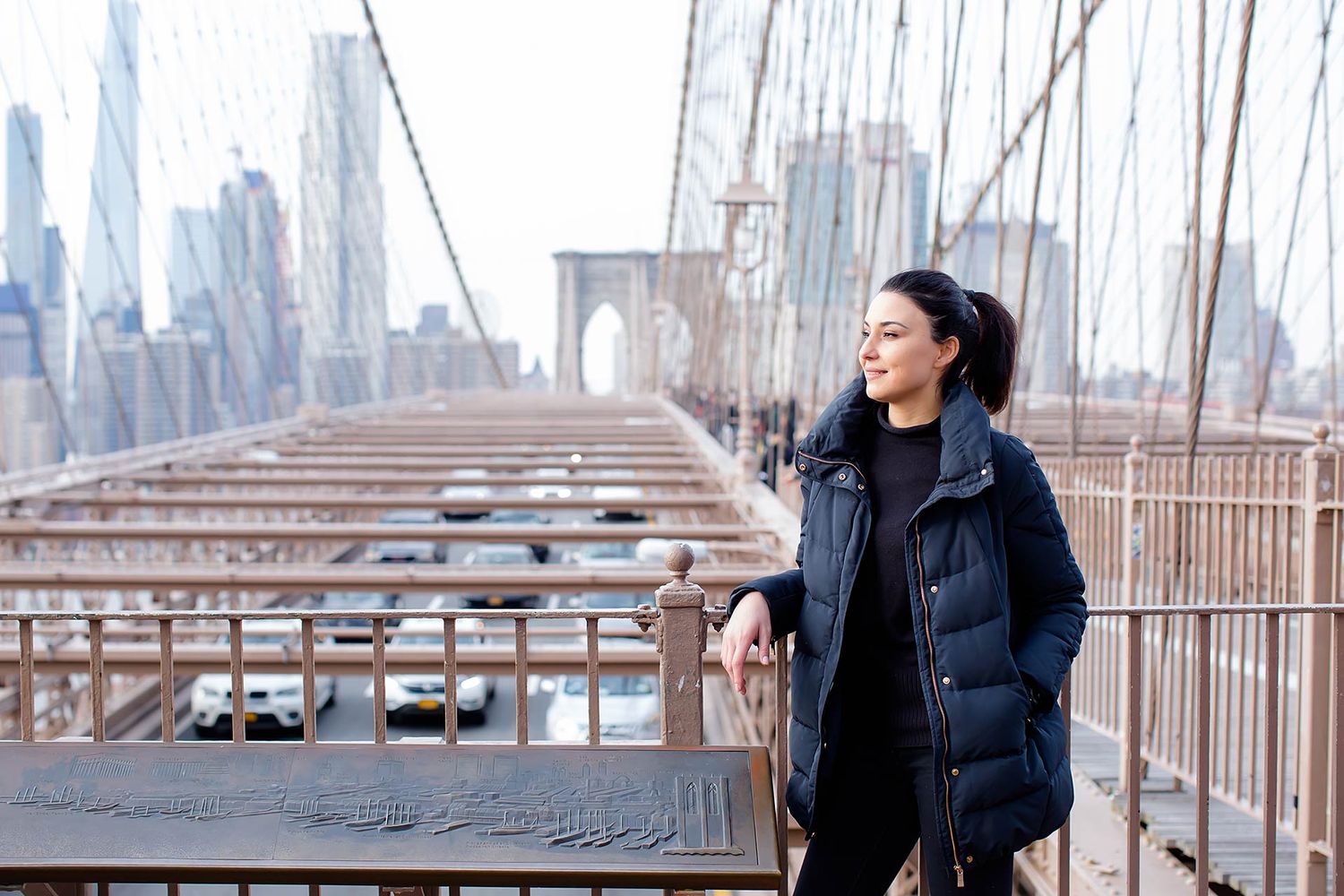 Winter portrait on Brooklyn Bridge with Manhattan skyline in background.
