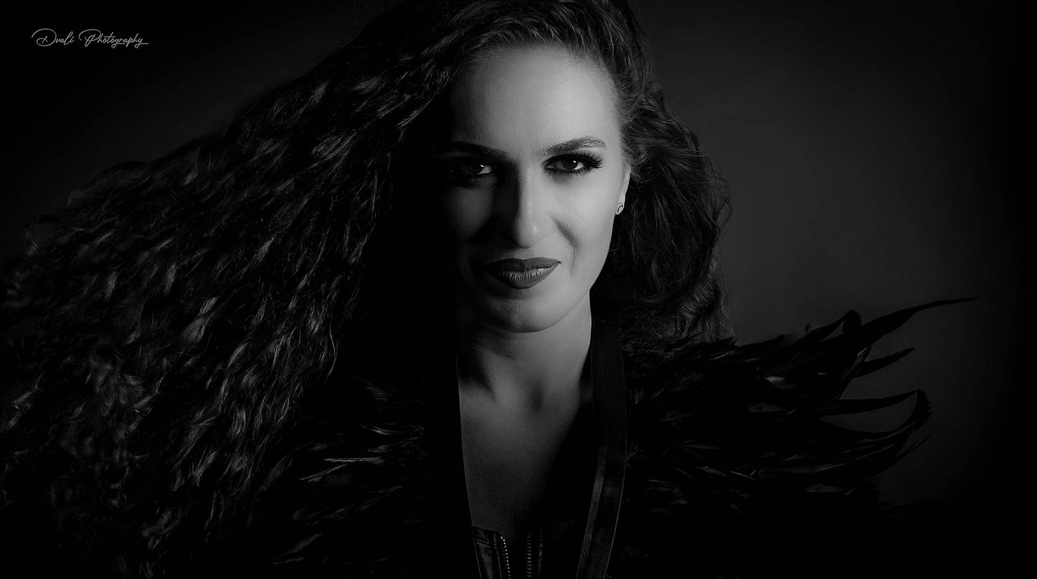 Dark and moody black and white portrait featuring dramatic shadows.