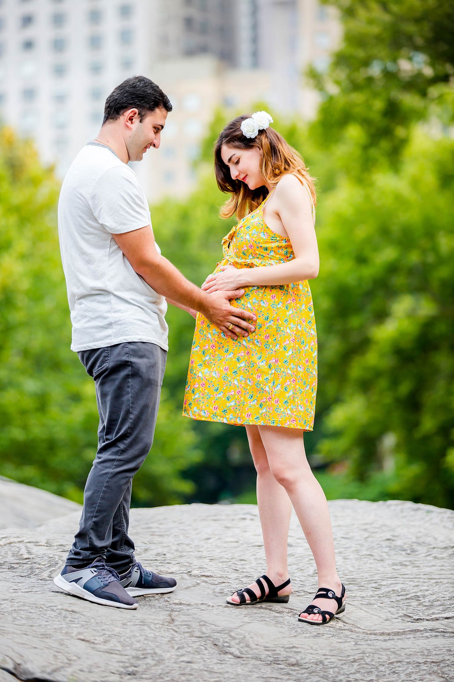 Couple playfully interacting on stone steps in park setting.