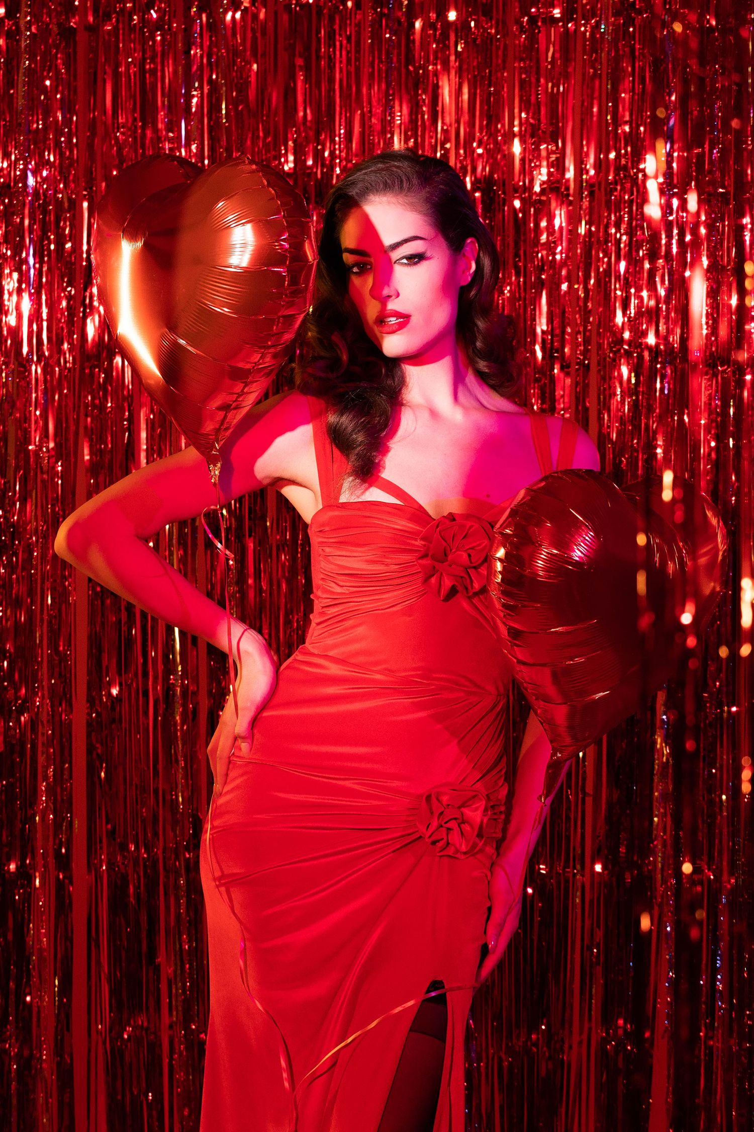 Glamorous movement sequence against shimmering red backdrop with dramatic lighting.