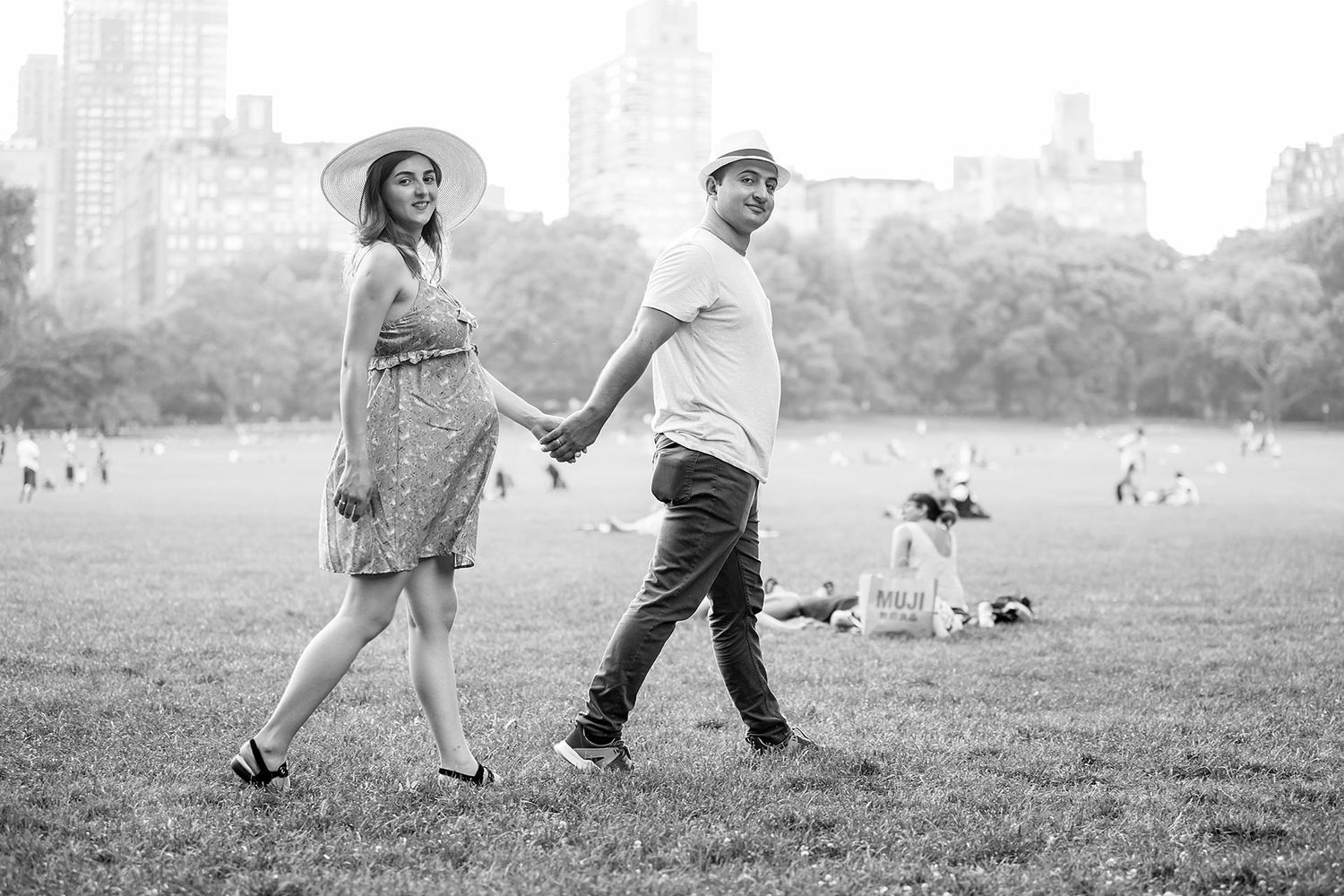 Black and white portrait of couple dancing in park.