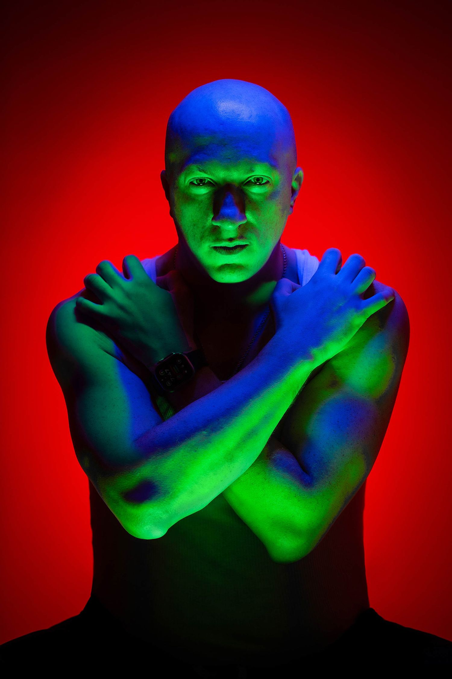 Artistic portrait sequence showing figure illuminated by dramatic red, blue and green lighting against dark background.