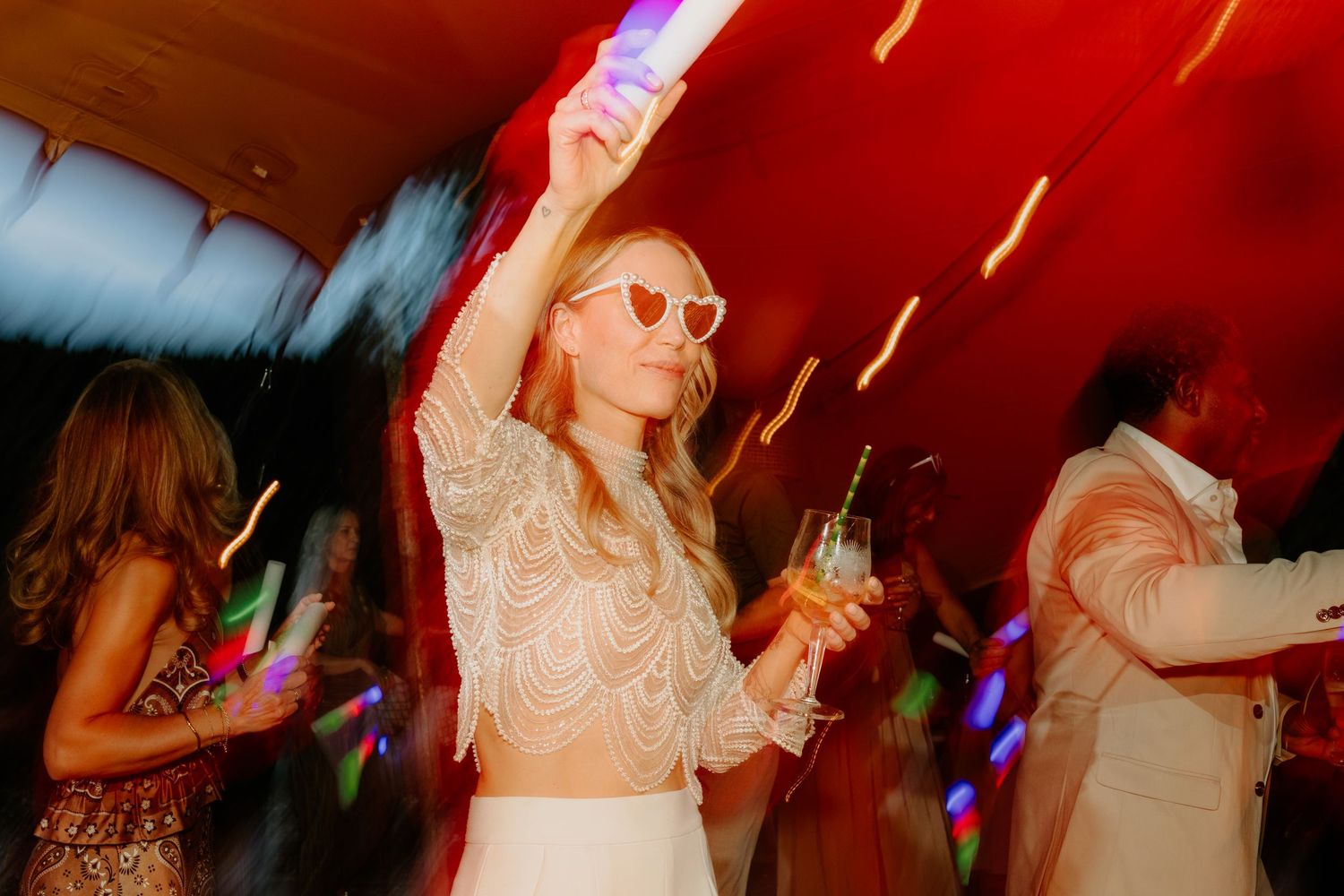 Dansende bruid met zonnebril tijdens een kleurrijk trouwfeest