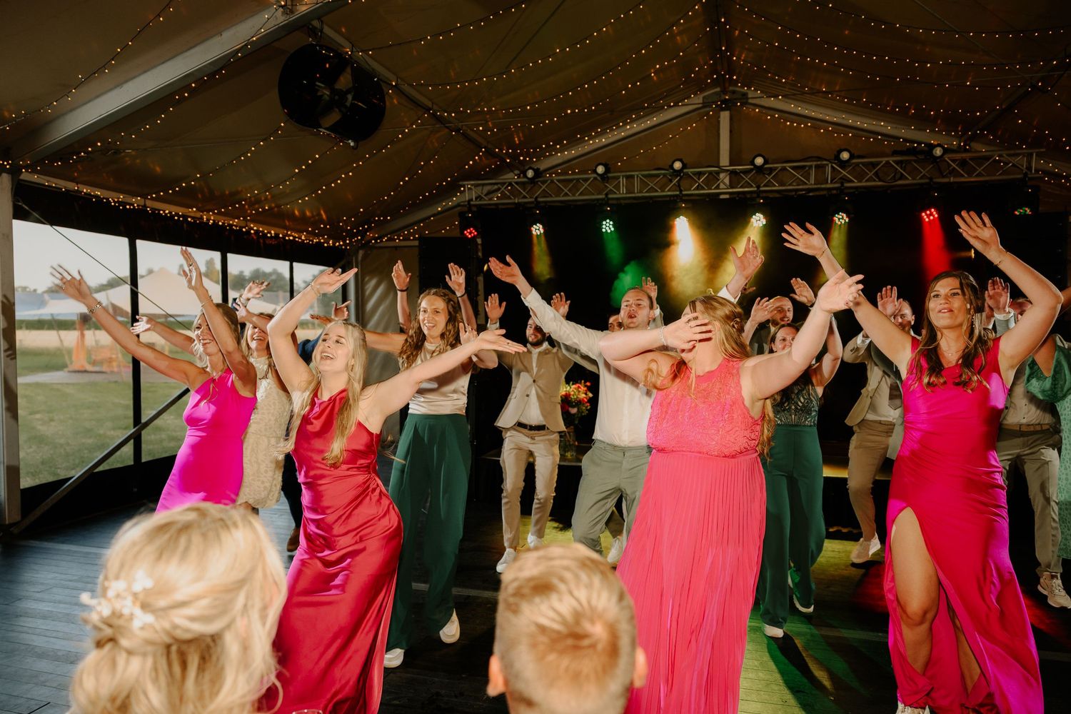 Bruiloftsgasten geven een dansoptreden tijdens het trouwfeest.