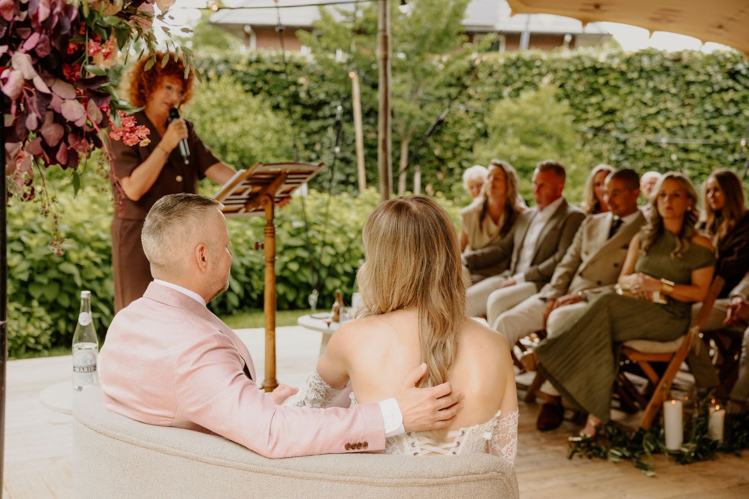 Ceremoniespreker spreekt het bruidspaar toe terwijl zij samen vooraan zitten