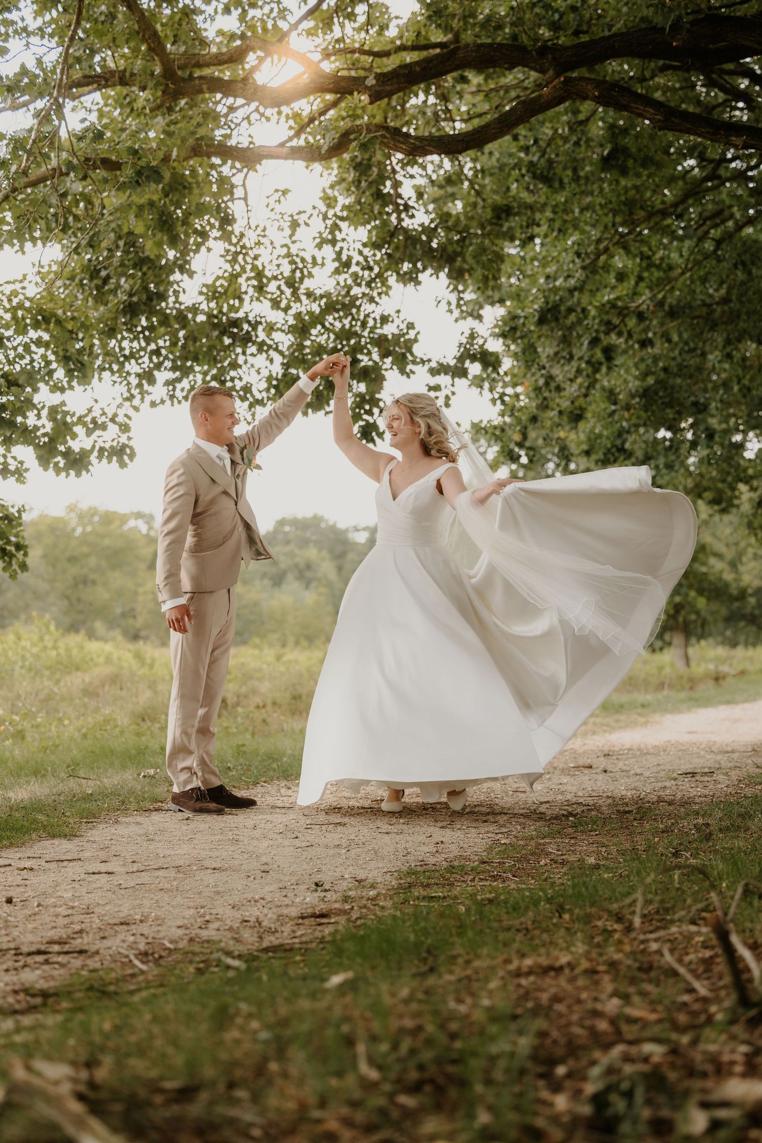 Een bruidspaar danst op een paadje in het bos
