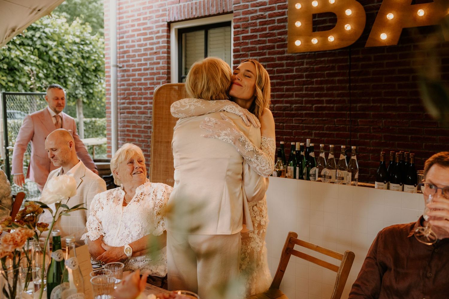 Bruid omhelst haar moeder na een speech tijdens het diner