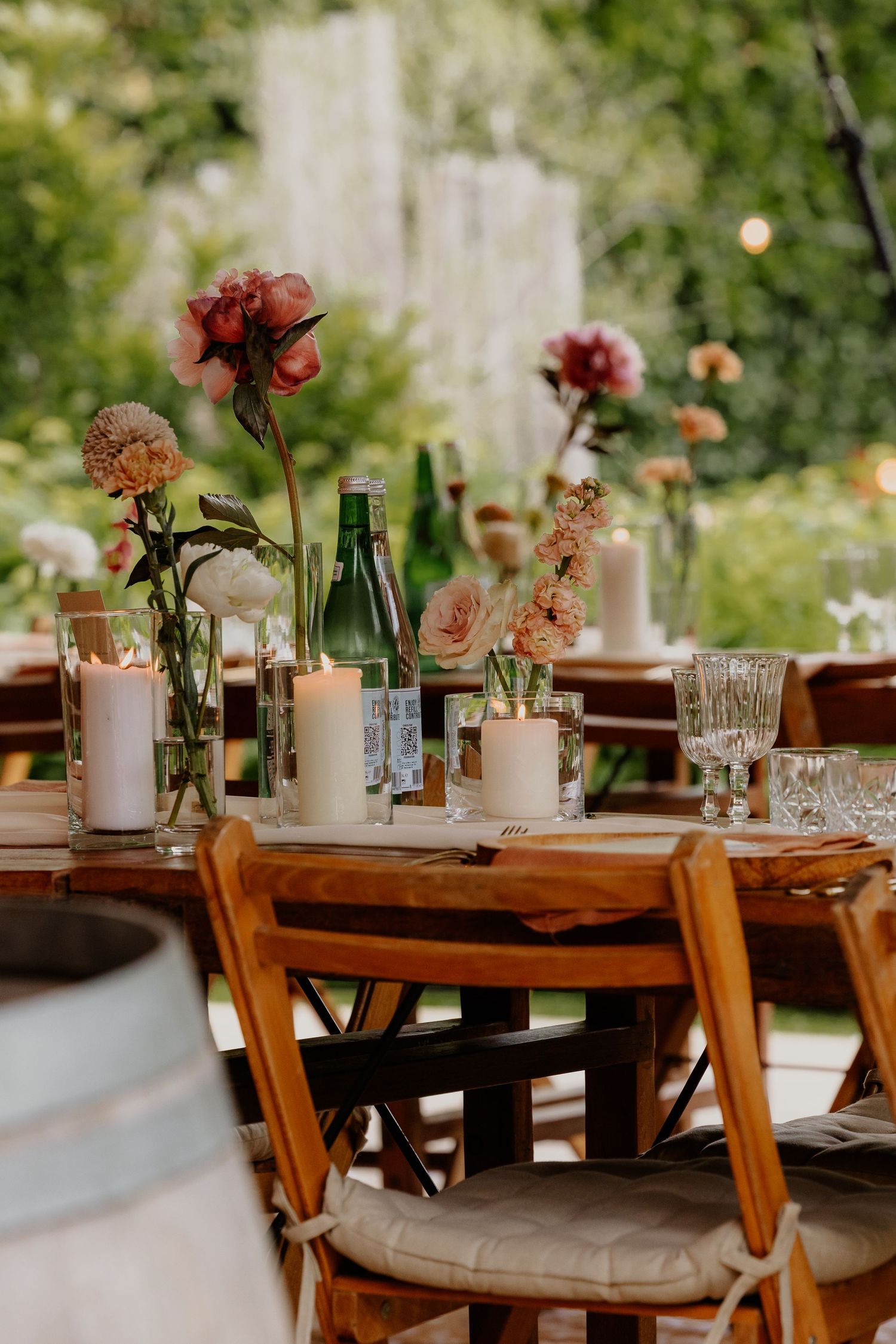 Gedekte dinertafel met kleurrijke bloemen voor een buitenbruiloft