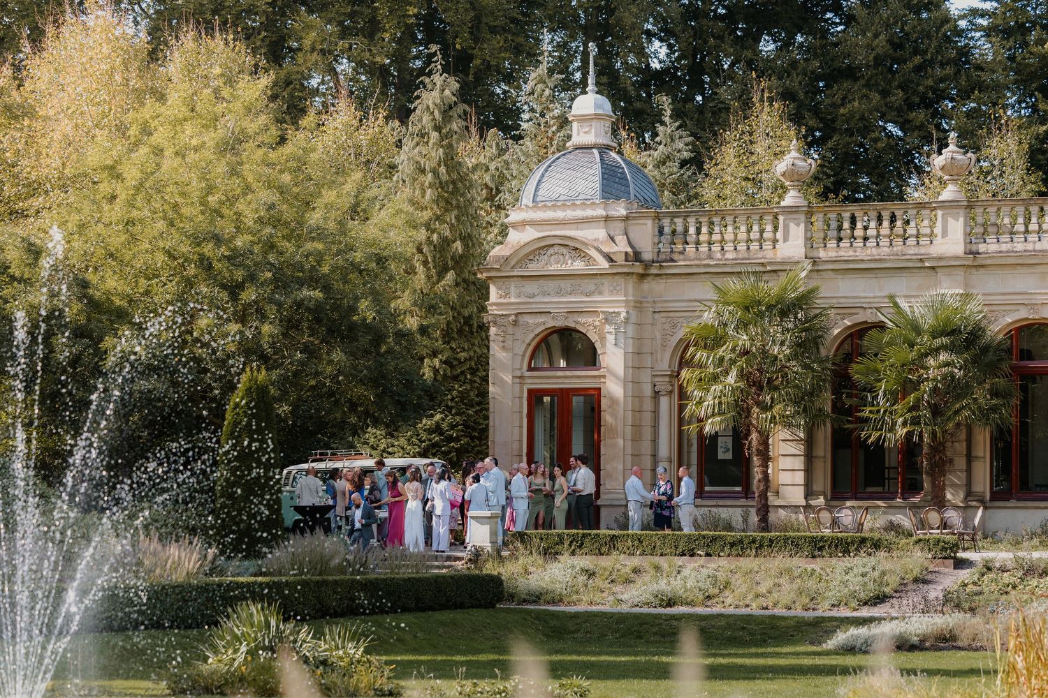 Bruiloftsgasten verzamelen zich bij een historische trouwlocatie tijdens een bruiloft