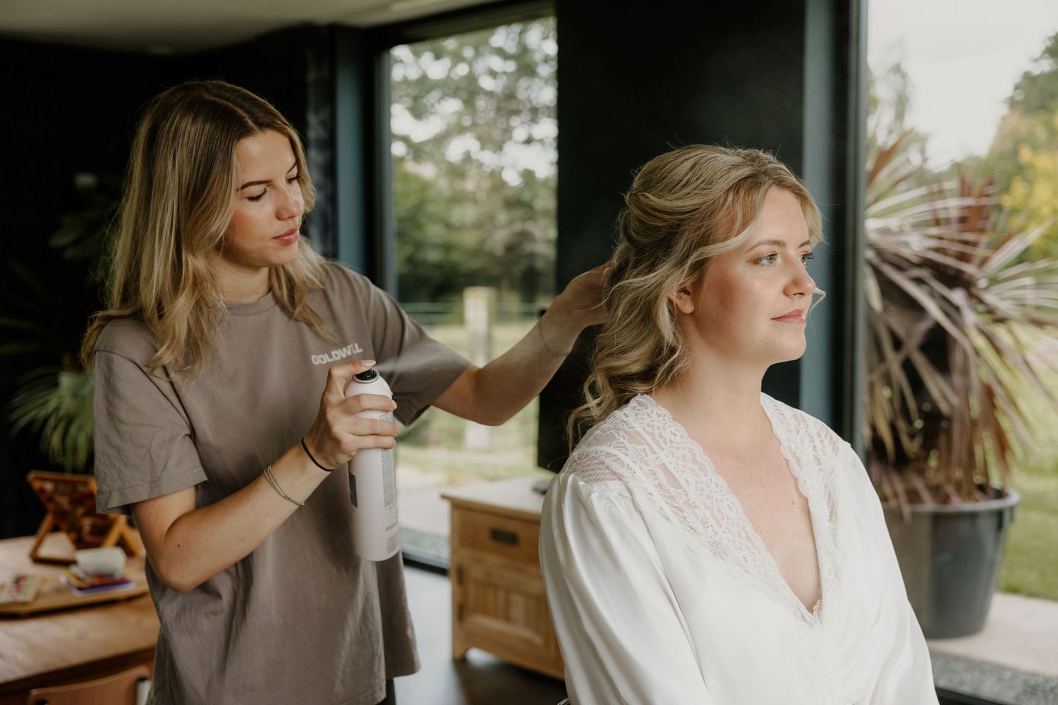 Haarstyling van de bruid tijdens de voorbereidingen op haar trouwdag