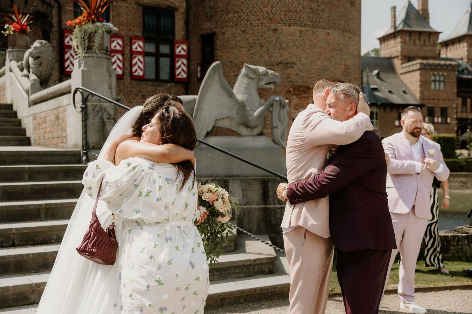 Het bruidspaar knuffelt innig hun beste vrienden na de ceremonie bij Kasteel de Haar.