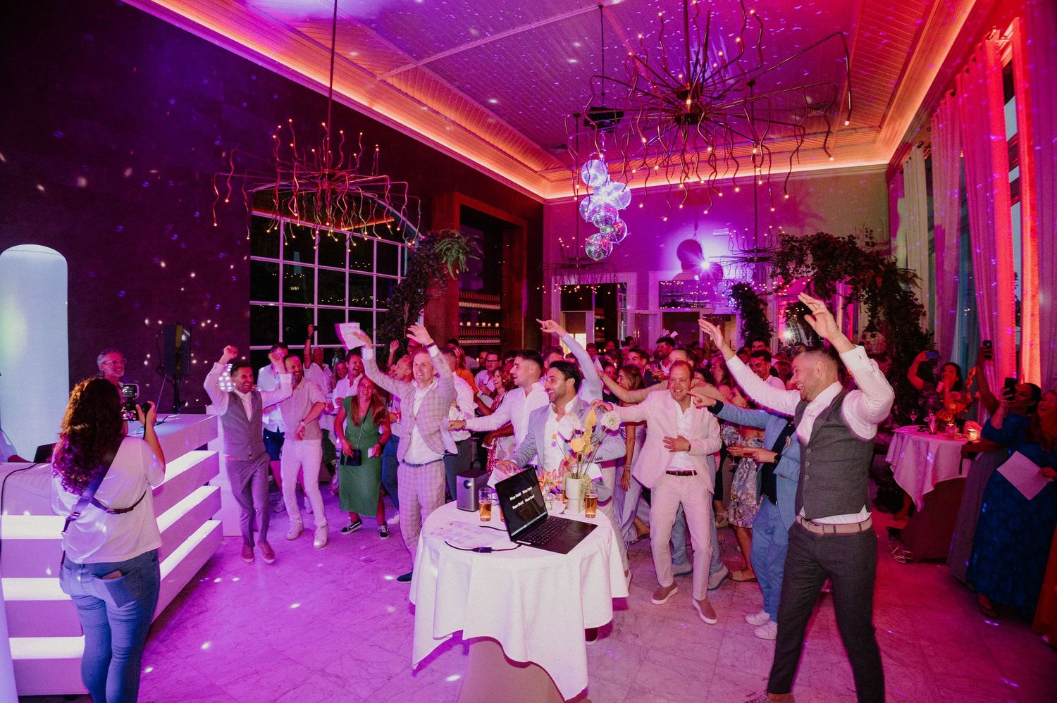 Overzicht van een volle dansvloer met feestende bruiloftsgasten.