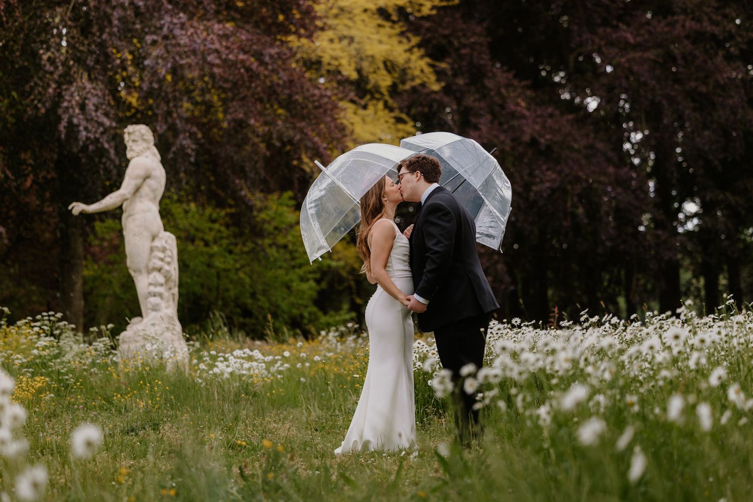 Bruid en bruidegom hebben samen plezier tijdens hun trouwfotoshoot in de regen