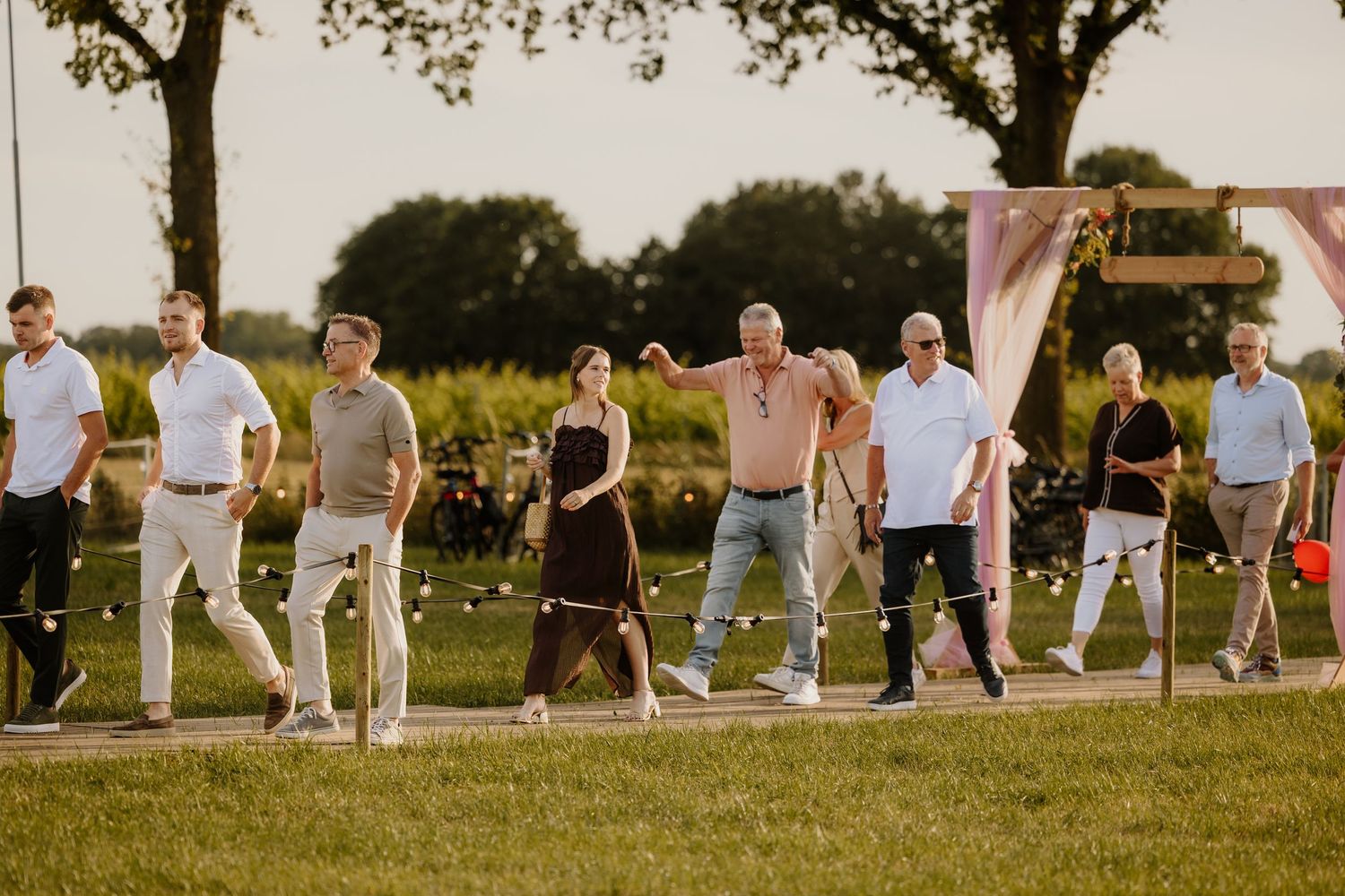 Gasten komen vol enthousiasme aanlopen voor het feest op een bruiloft in de avond.