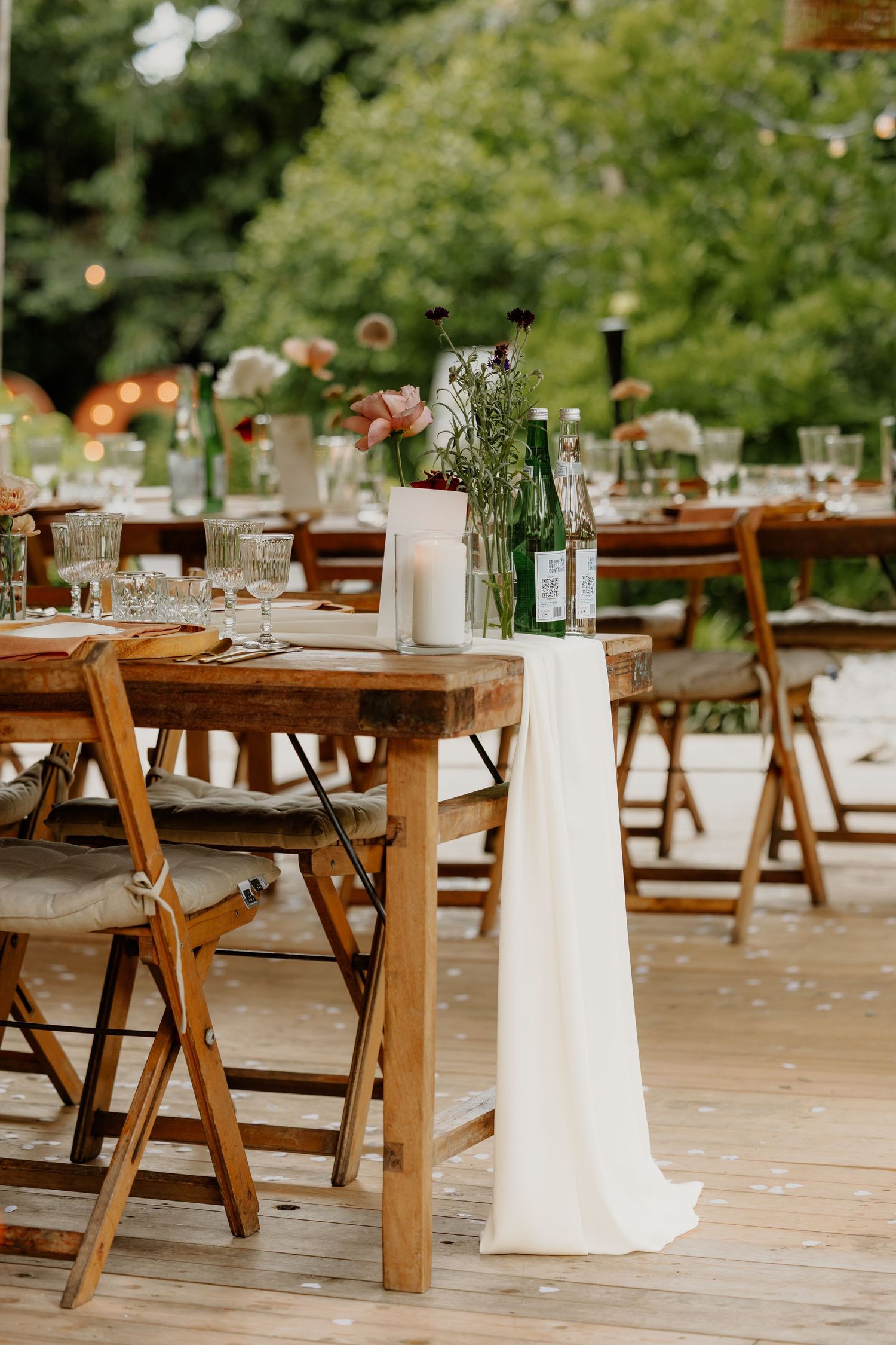 Lange gedekte tafels voor een sfeervol bruiloftsdiner in de buitenlucht