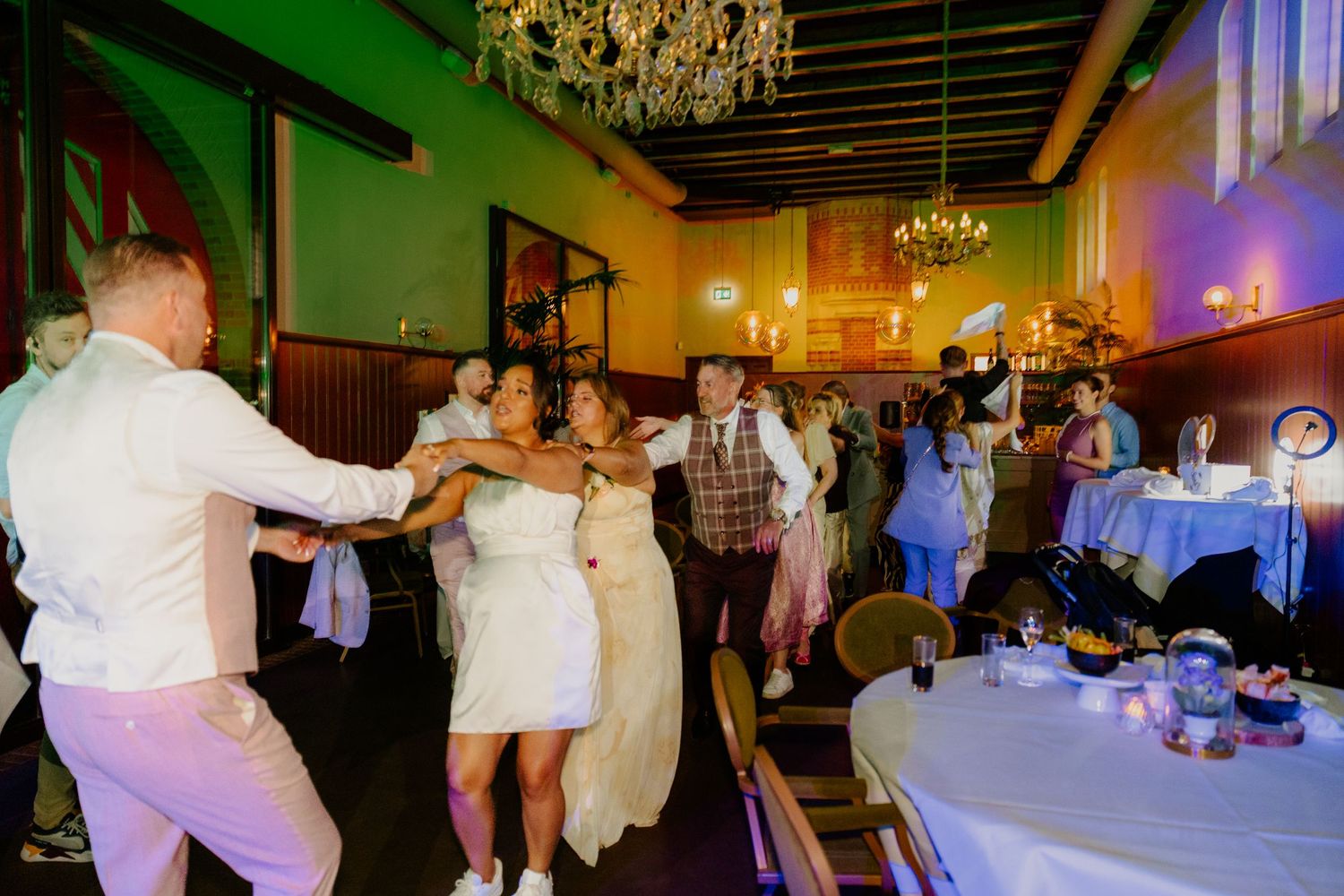 Bruidspaar danst samen tussen de gasten tijdens het trouwfeest