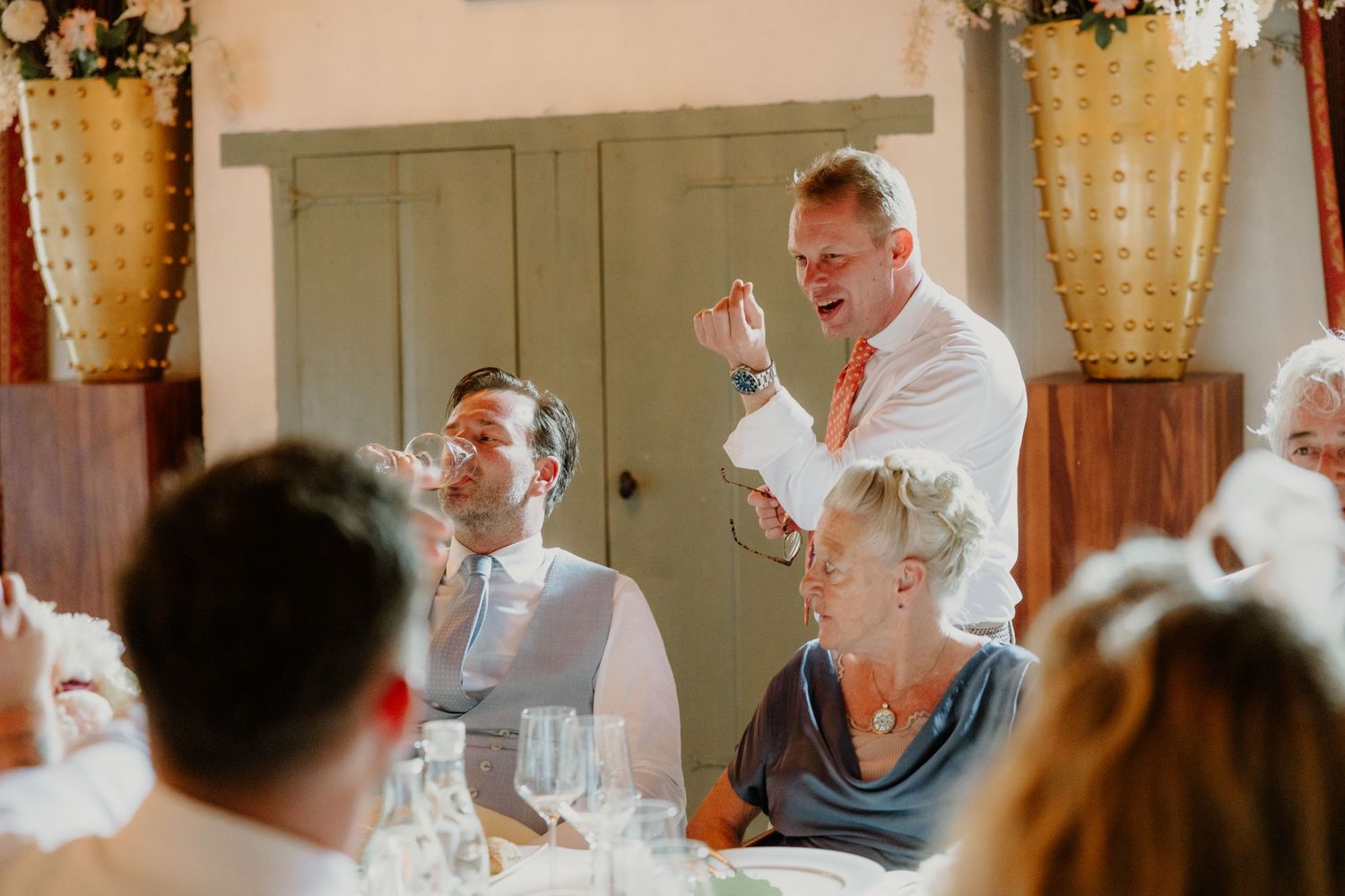 Gast houdt een vrolijke gesprek met gasten tijdens het bruiloftsdiner