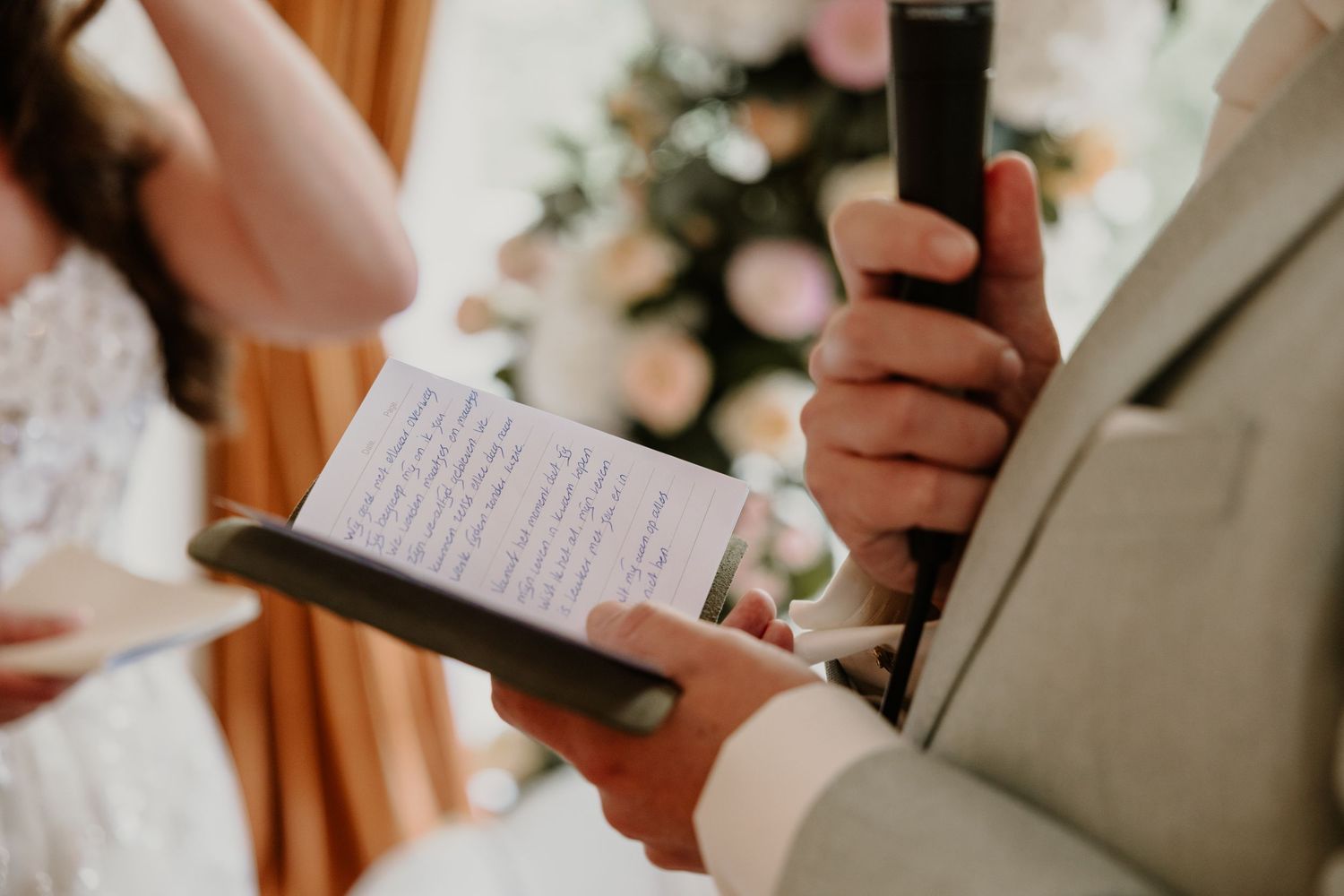 Detail van de bruidegom die zijn persoonlijke geloften voorleest tijdens de ceremonie