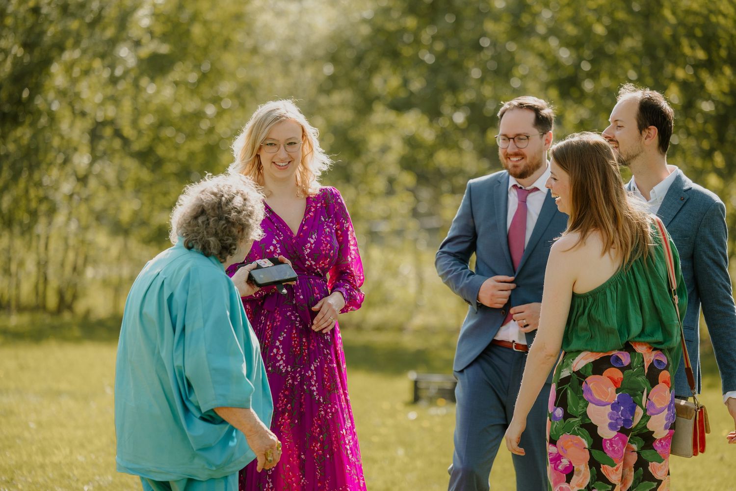 Bruiloftsgasten genieten samen van een zonnige buitenbruiloft