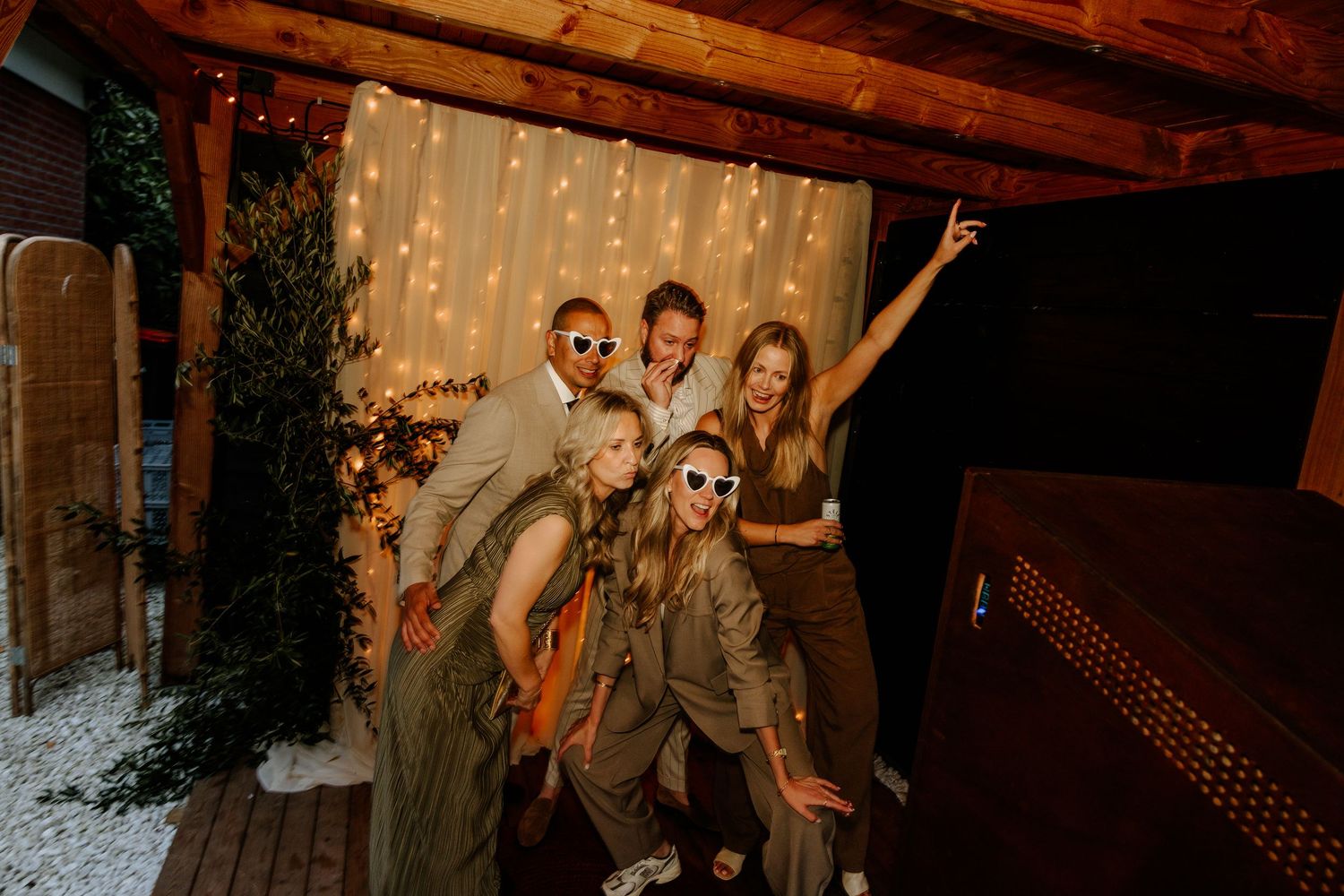 vrienden poseren voor de photobooth tijdens een feestelijke avondfoto