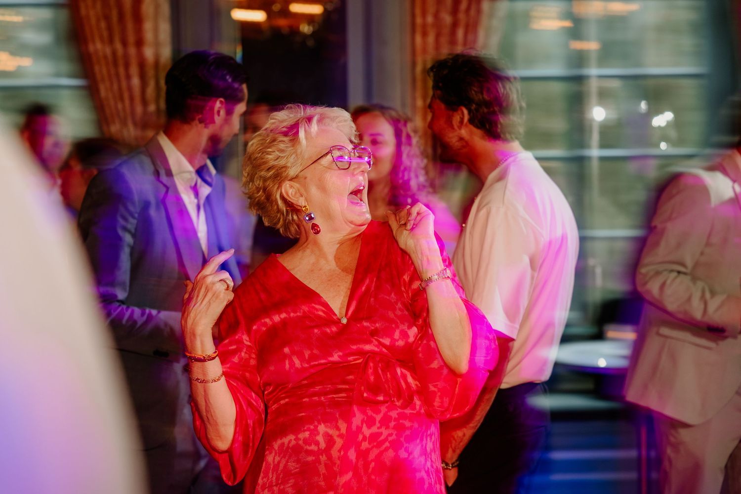Lachende bruiloftsgast op de dansvloer tijdens het trouwfeest