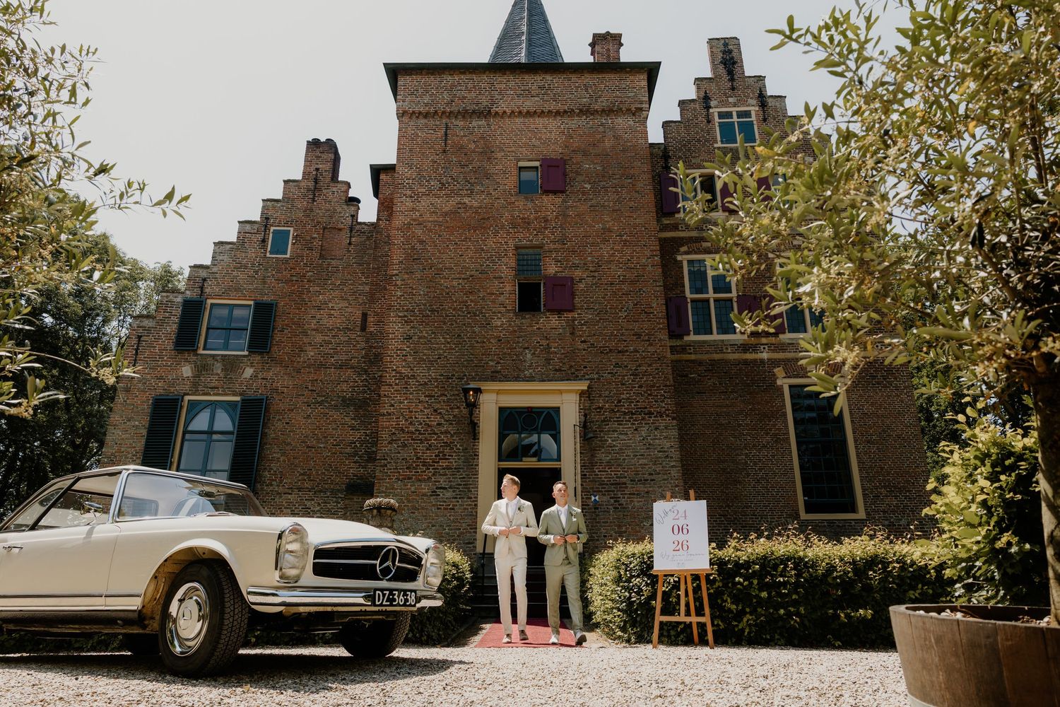 Twee bruidegommen poseren voor Kasteel Wijenburgh