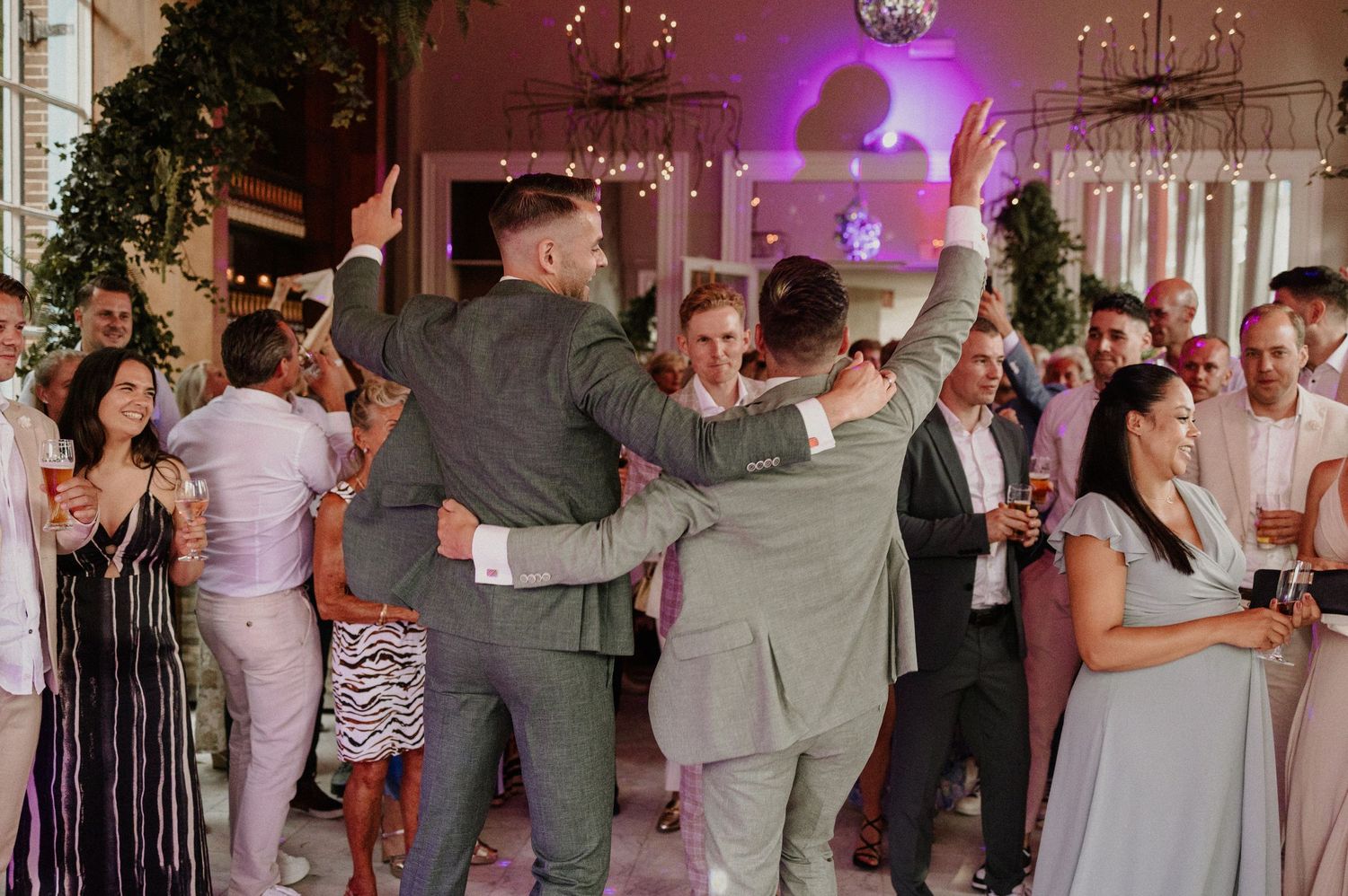 Bruiloftsgasten dansen samen op de dansvloer tijdens het trouwfeest.