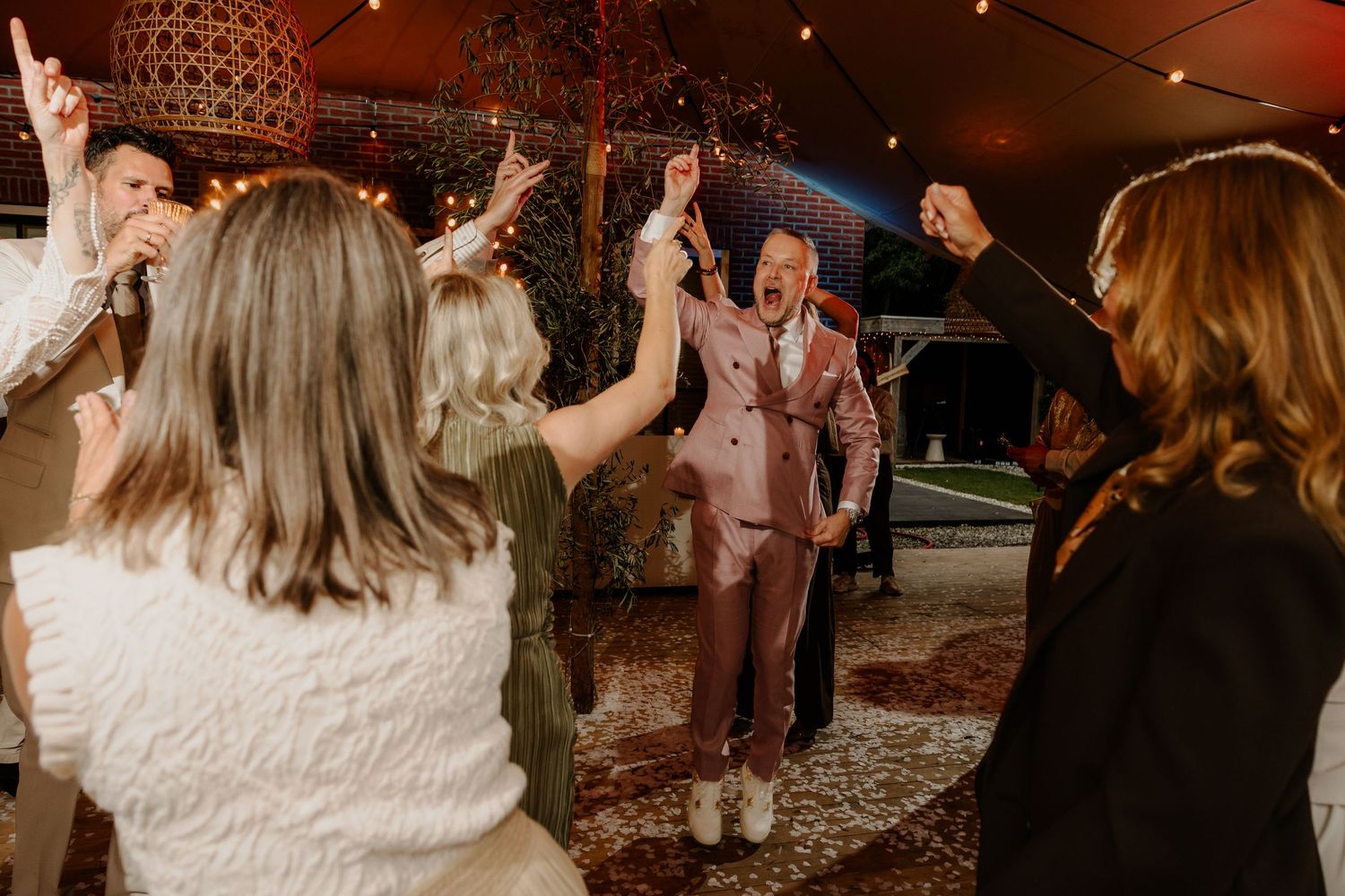 Bruidegom danst tussen de gasten tijdens het trouwfeest