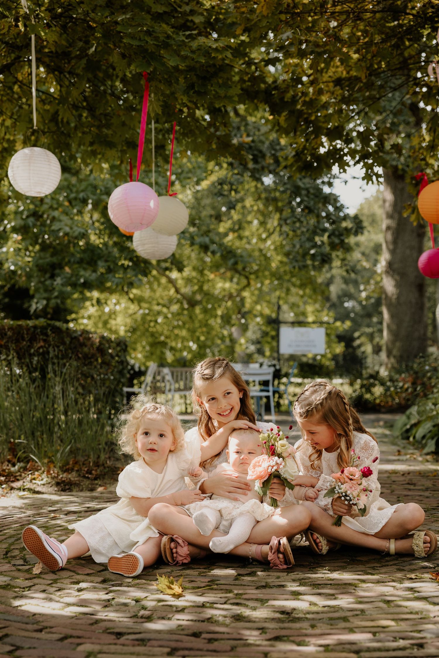 Kinderen zitten samen voor een groepsfoto tijdens een ontspannen moment op de bruiloft