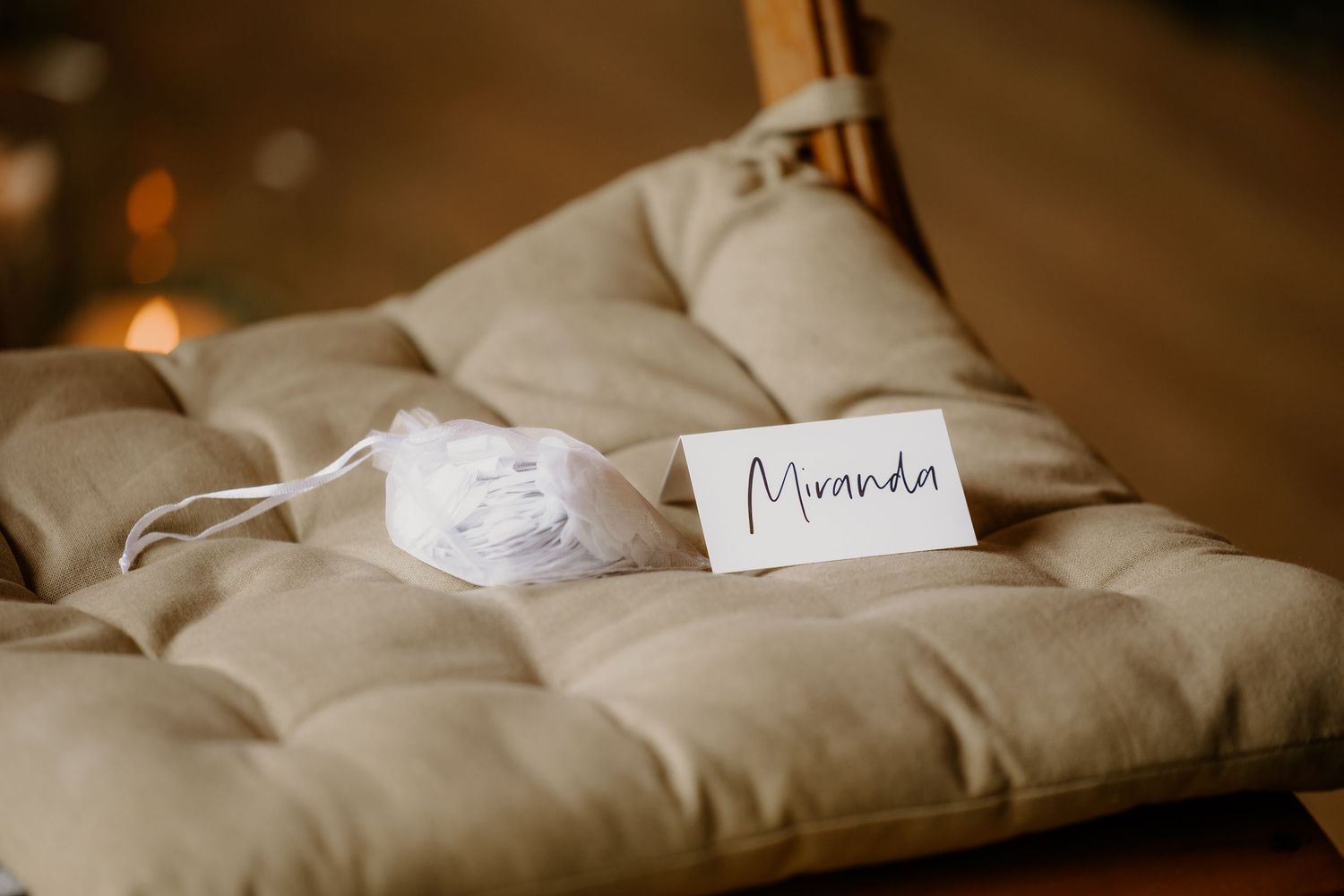 Naamkaartje en klein cadeautje voor een bruiloftsgast op een ceremoniestoel