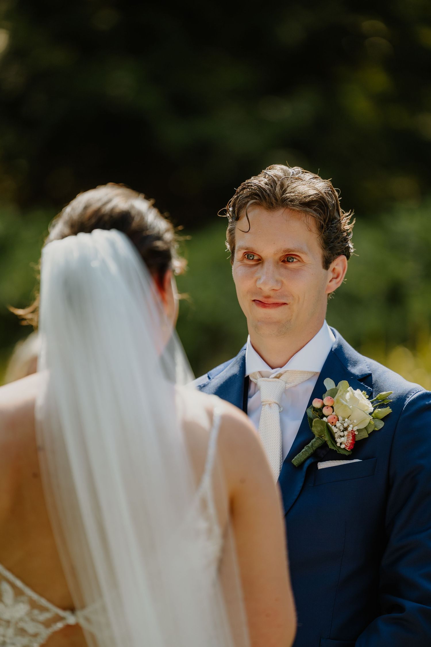 Bruidegom kijkt geëmotioneerd naar zijn bruid tijdens de trouwceremonie