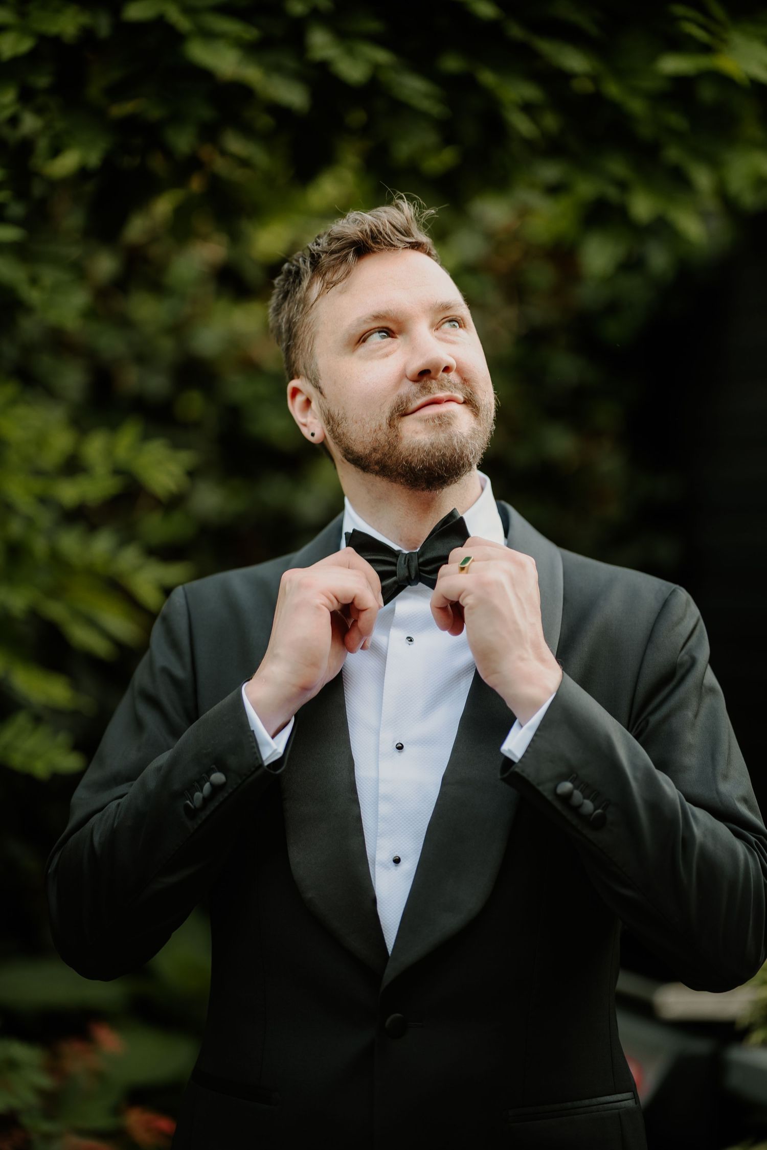 Trouwfotograaf André trekt zijn strik van zijn pak goed.