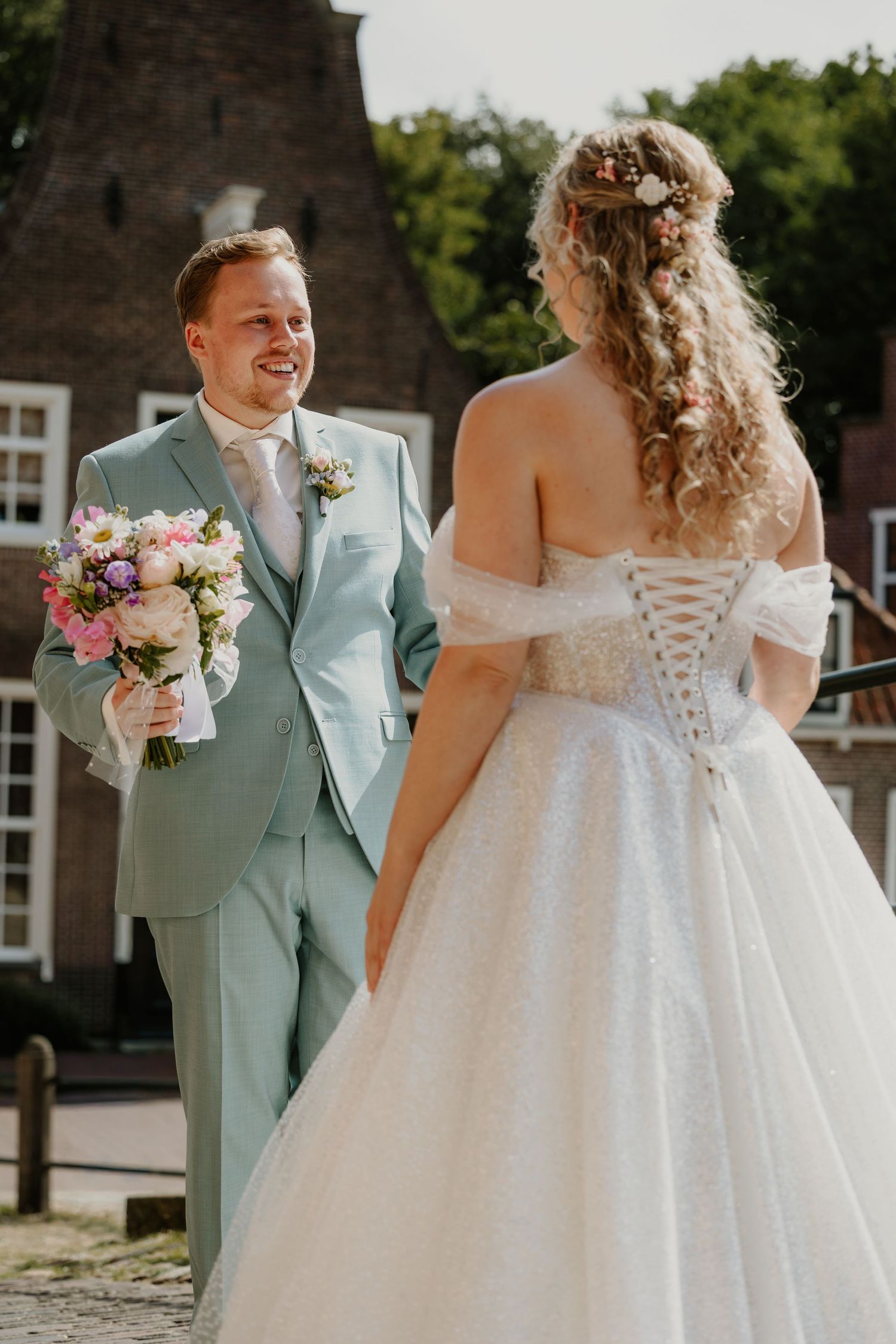 Bruidegom ziet zijn bruid tijdens een first look buiten in de binnenstad van Amersfoort