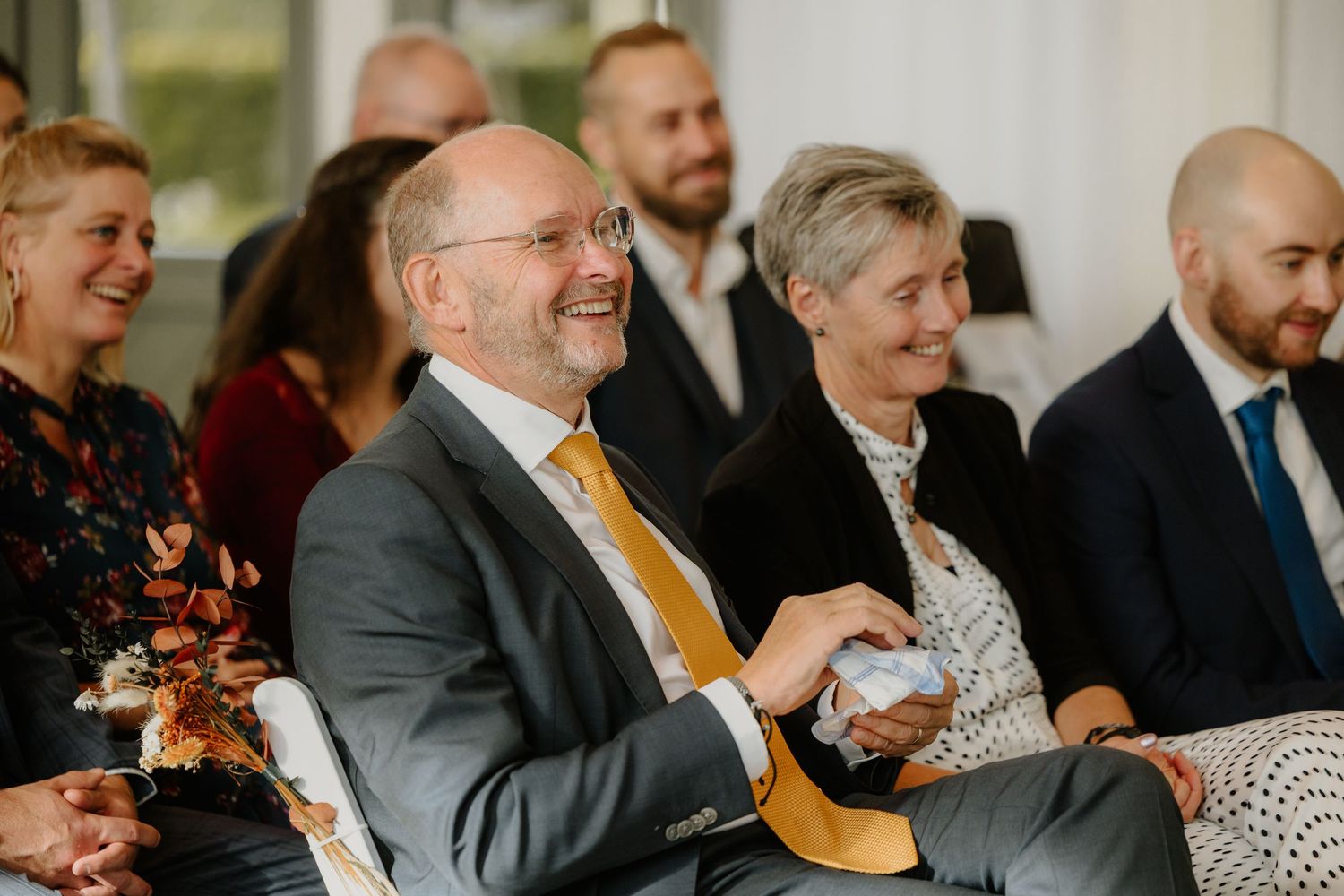 De vader van de bruid moet lachen tijdens de ceremonie
