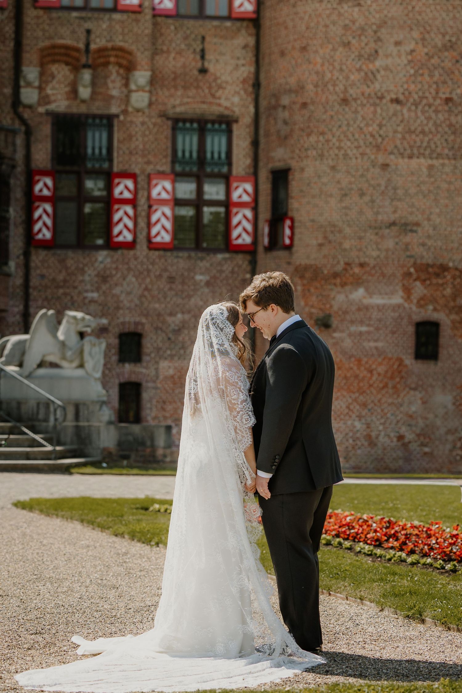 Bruidspaar staat samen voor een historische trouwlocatie