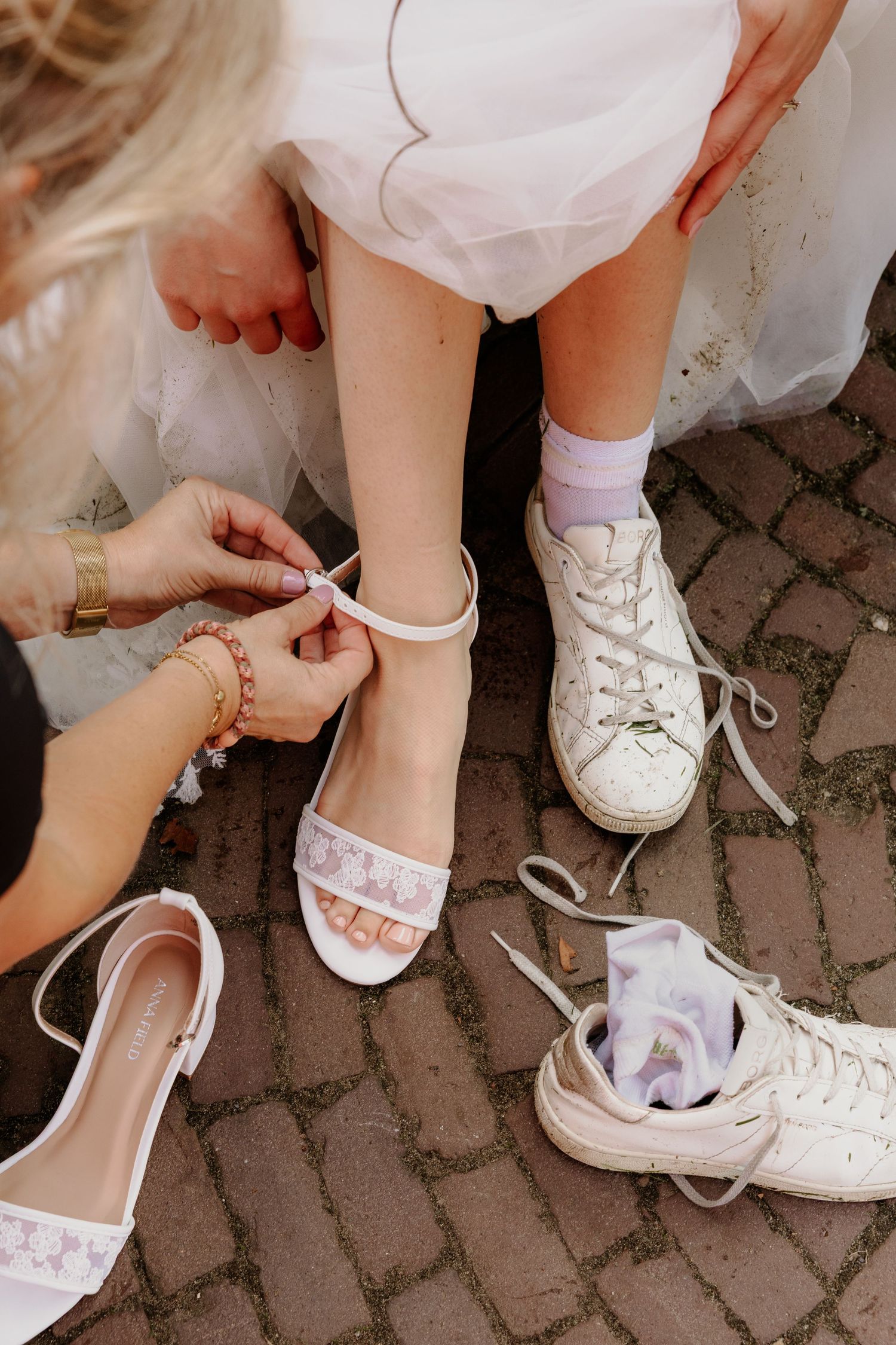 Detail van de bruid terwijl haar schoenen worden vastgemaakt