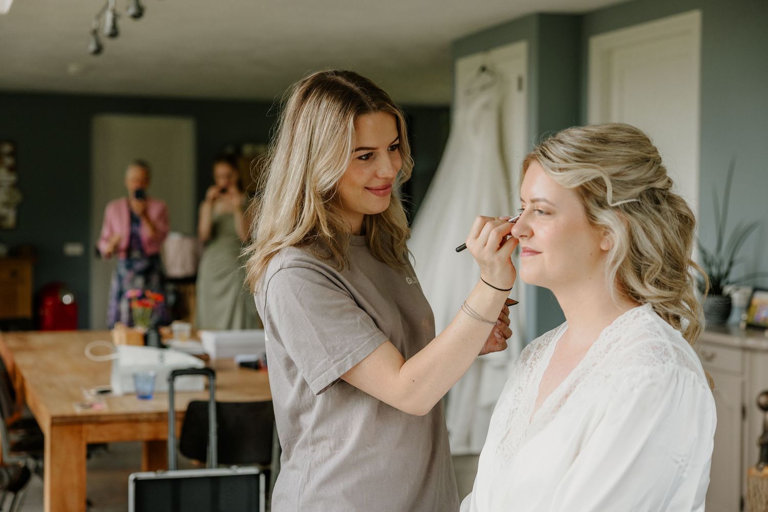 Bruid laat haar haar en make-up verzorgen tijdens de getting ready