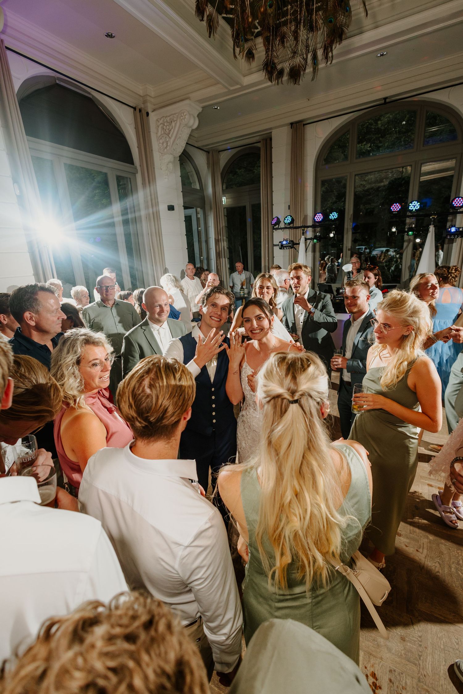 Feestende bruiloftsgasten rondom het bruidspaar op de dansvloer
