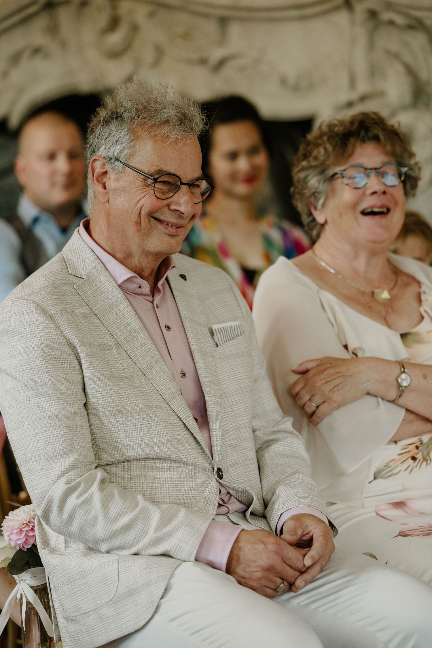 Gasten lachen zichtbaar tijdens een persoonlijk moment in de trouwceremonie