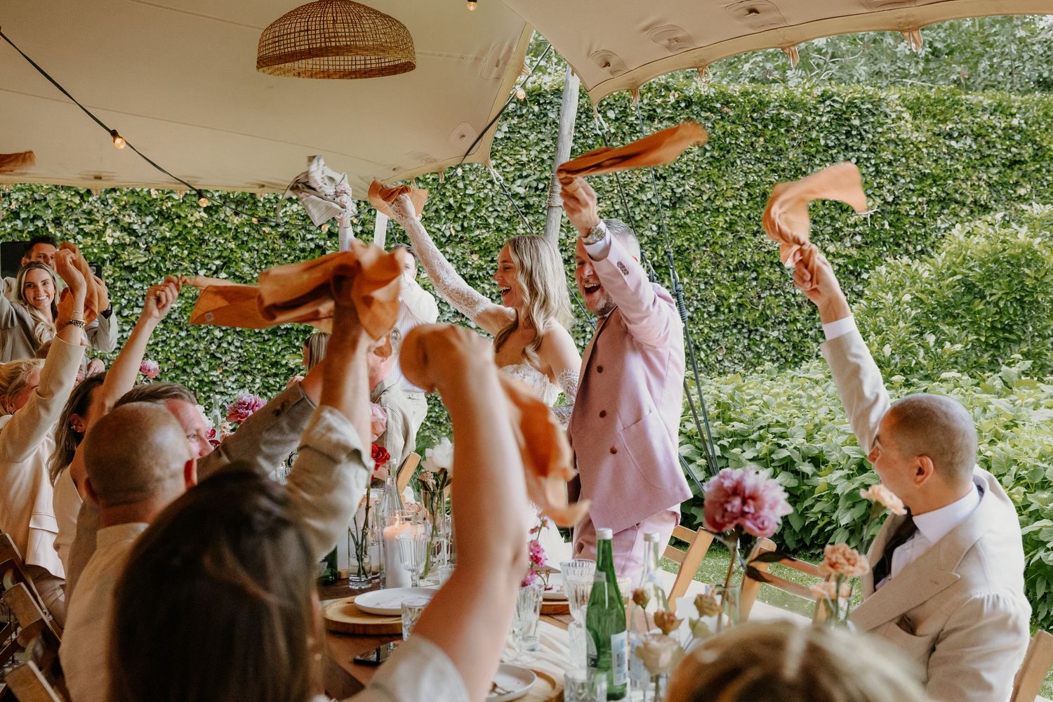 Bruidspaar en gasten proosten samen tijdens het bruiloftsdiner