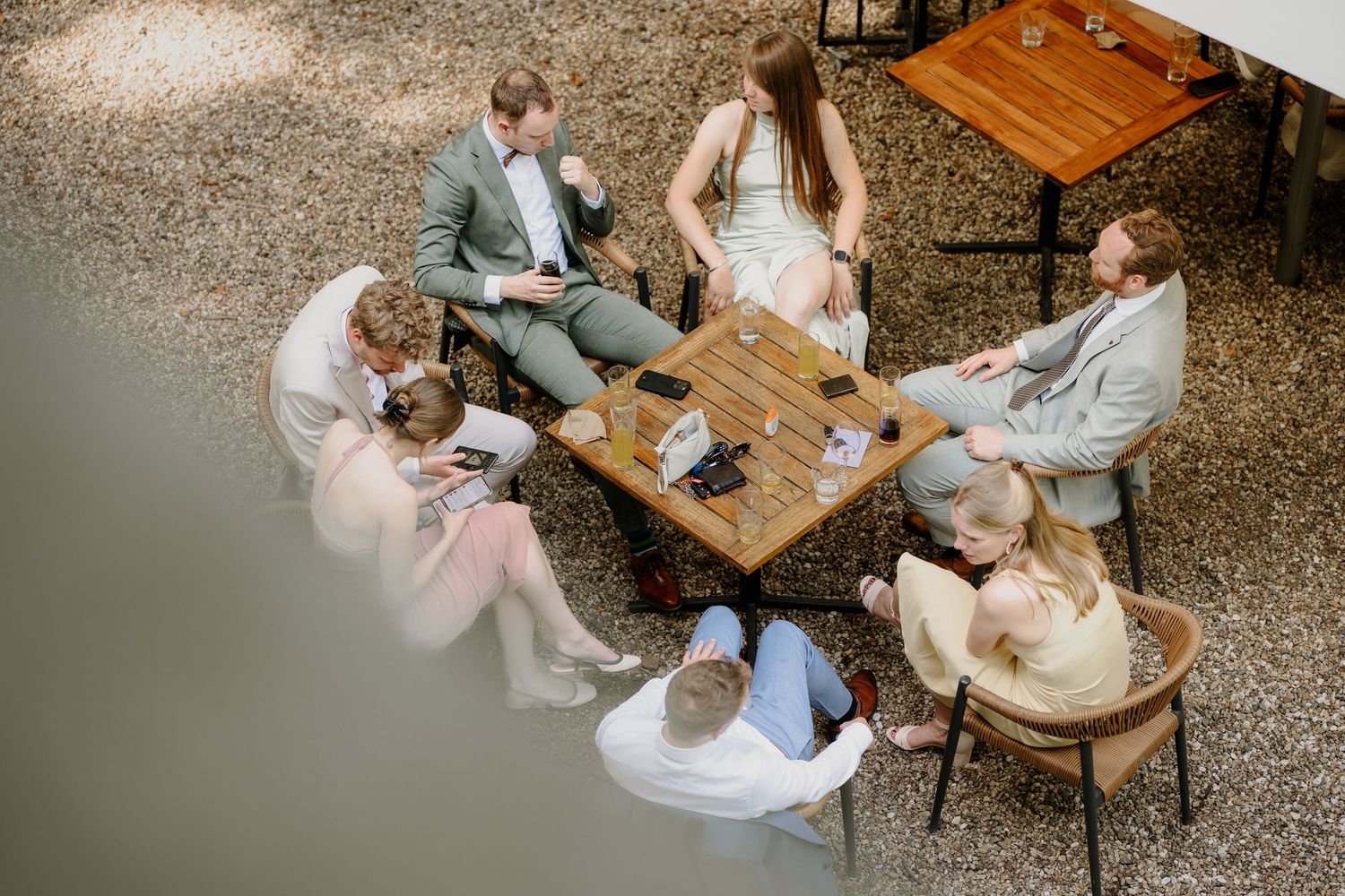 Bruiloftsgasten zitten samen rond een tafel tijdens een gezellig moment