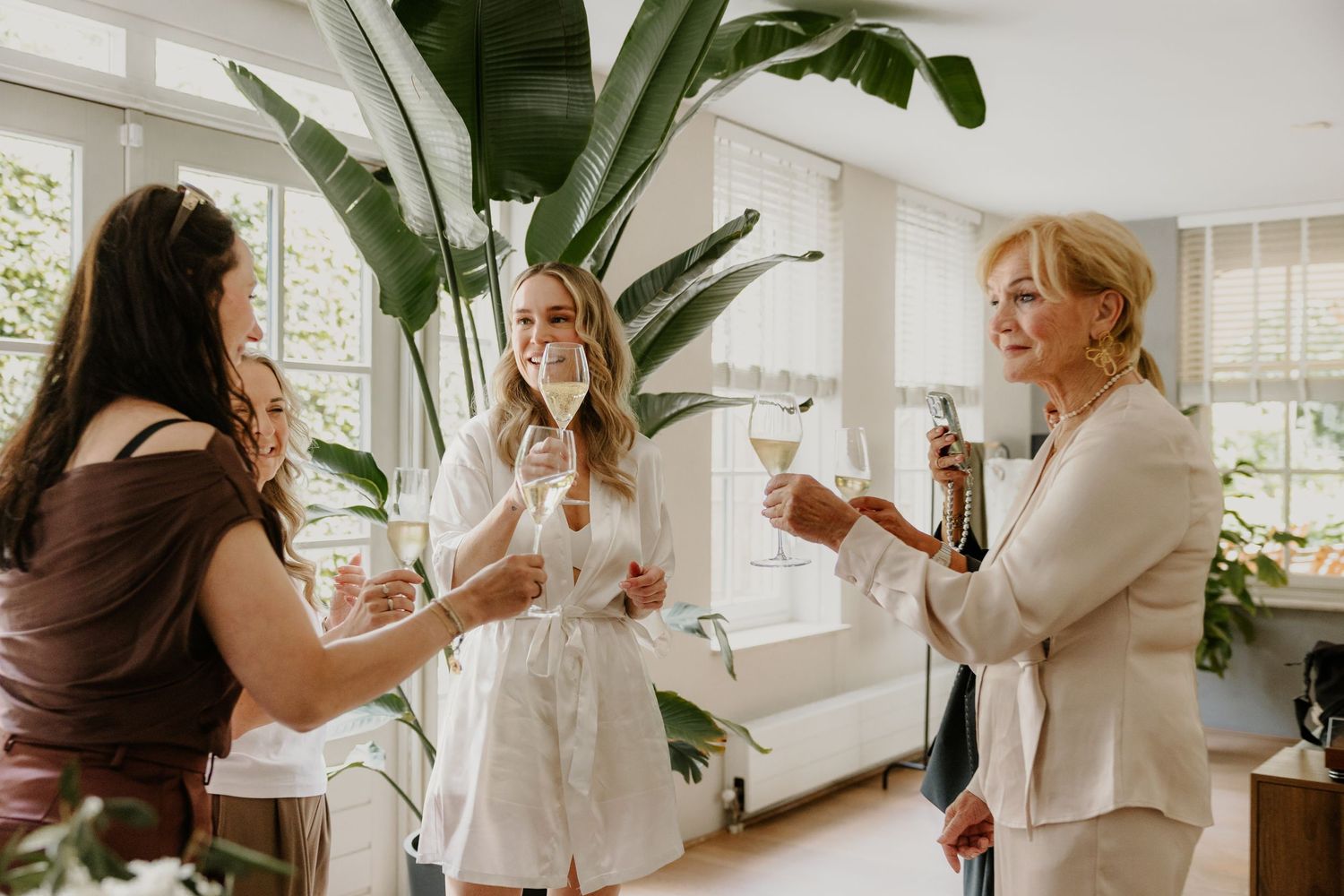Bruid proost met haar vriendinnen tijdens de voorbereidingen