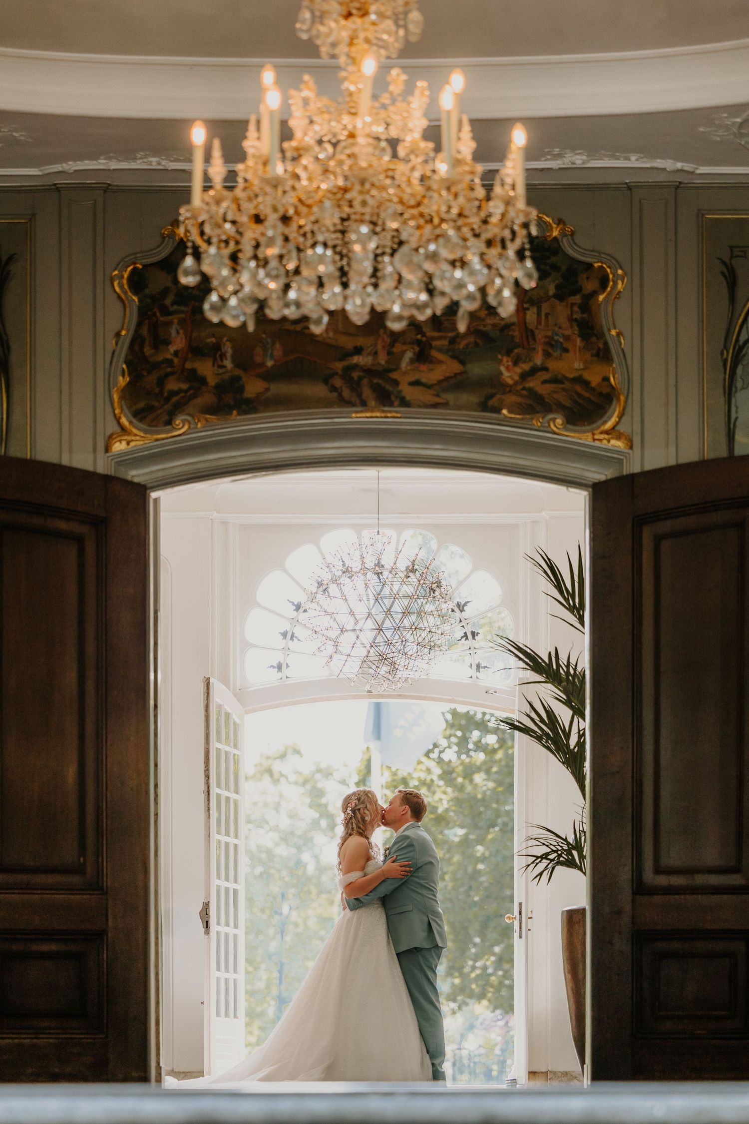 Bruidspaar samen in een deuropening van de trouwlocatie