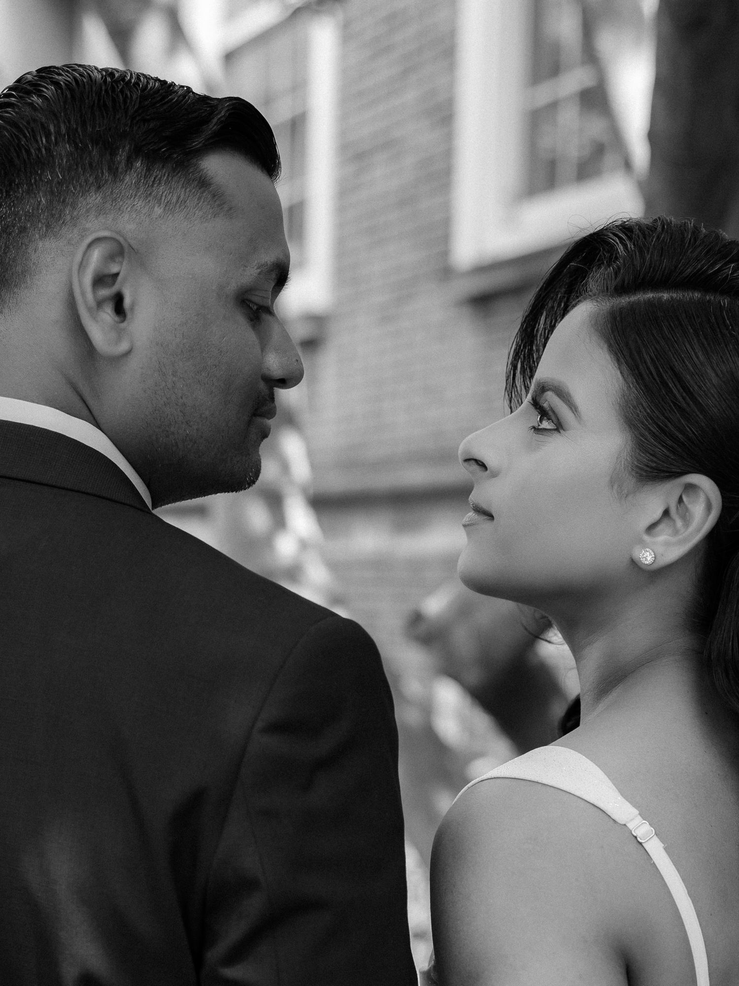 Black and white close-up portrait of bride and groom gazing into each other's eyes.