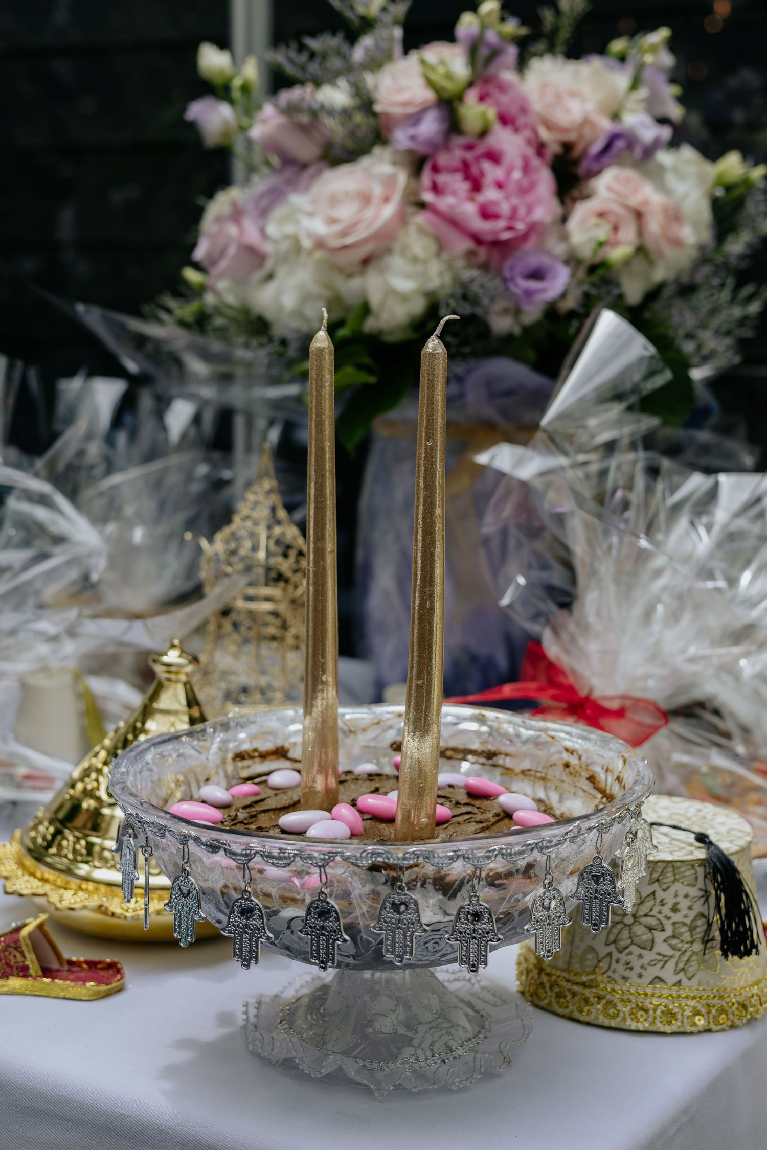 Traditional Moroccan wedding henna tray with gold candles, pink candy hearts and floral arrangements.