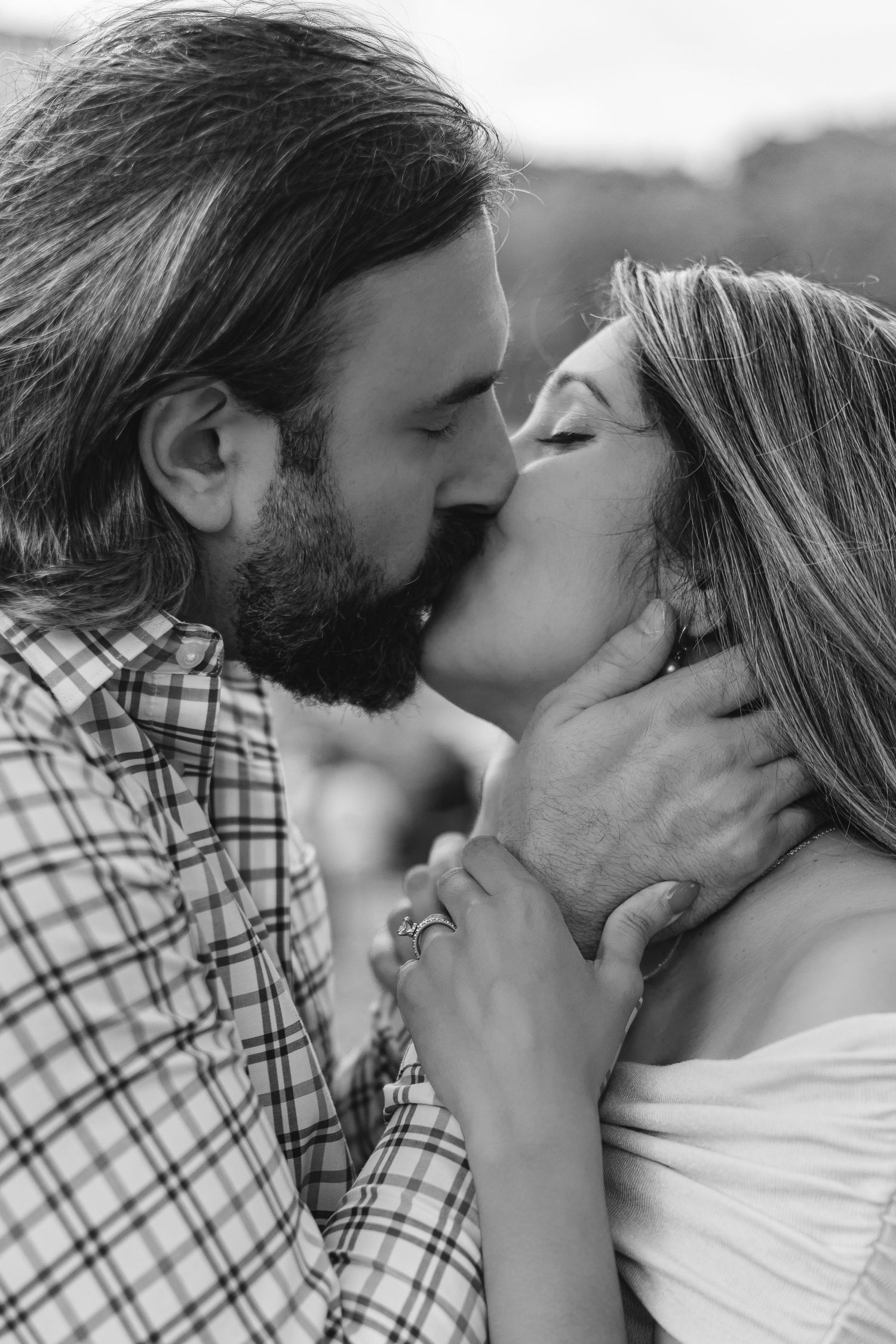Black and white photo of couple sharing a tender kiss during maternity session.
