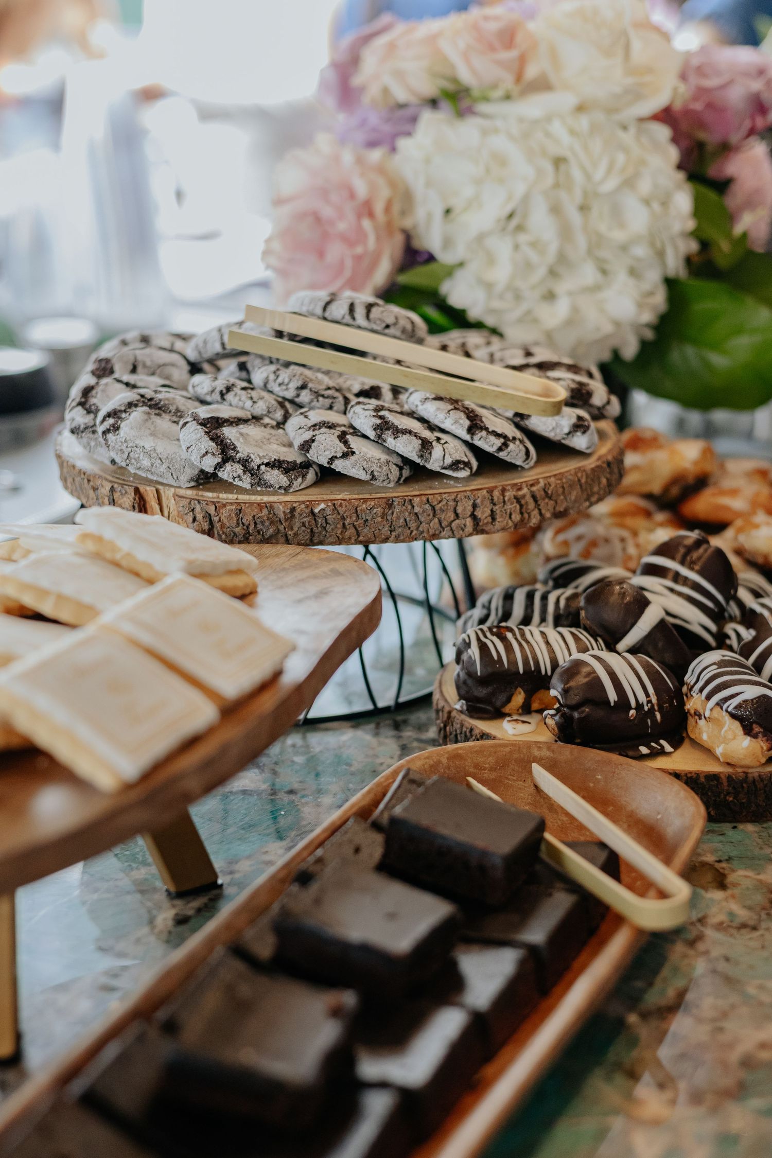 Assorted dessert table with crinkle cookies, brownies, and chocolate-dipped treats at a bridal shower.